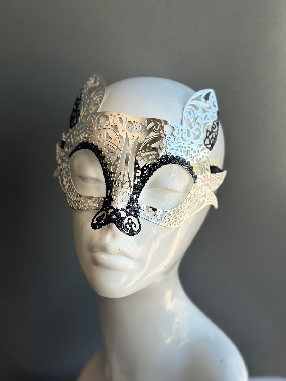 Silver laser cut metal lemur masquerade mask with black shimmer.