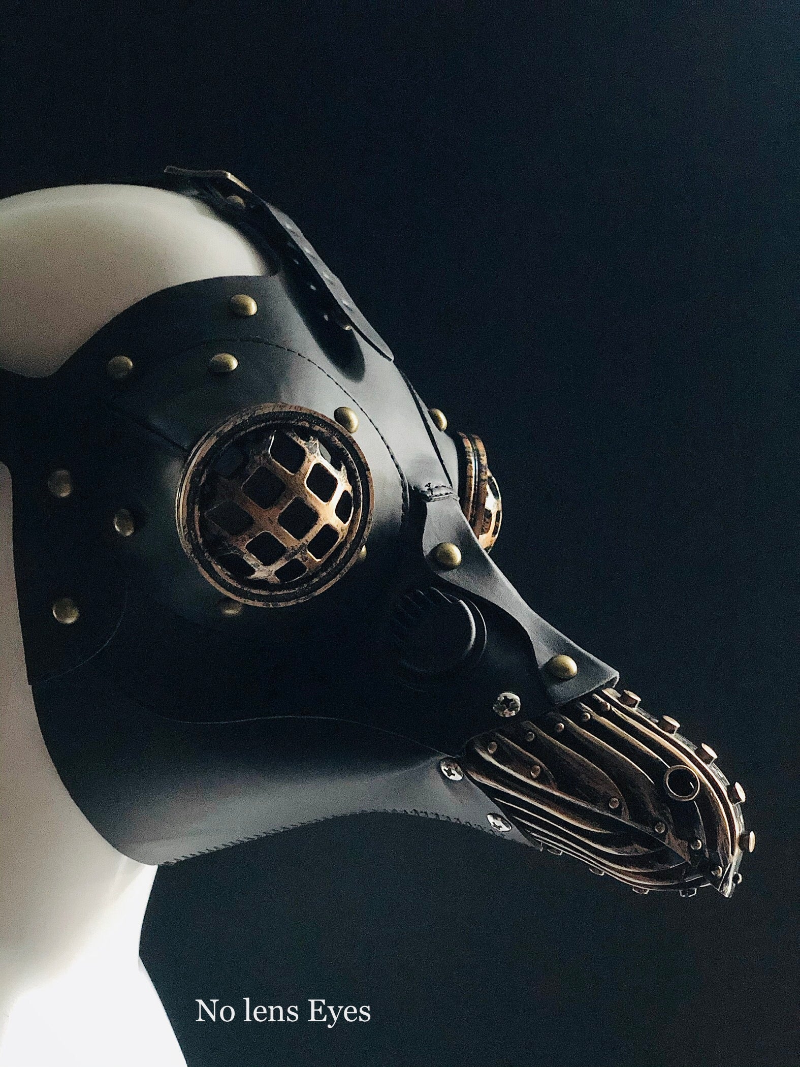 Cosplay-ready black plague mask featuring bronzed industrial cage-eye design