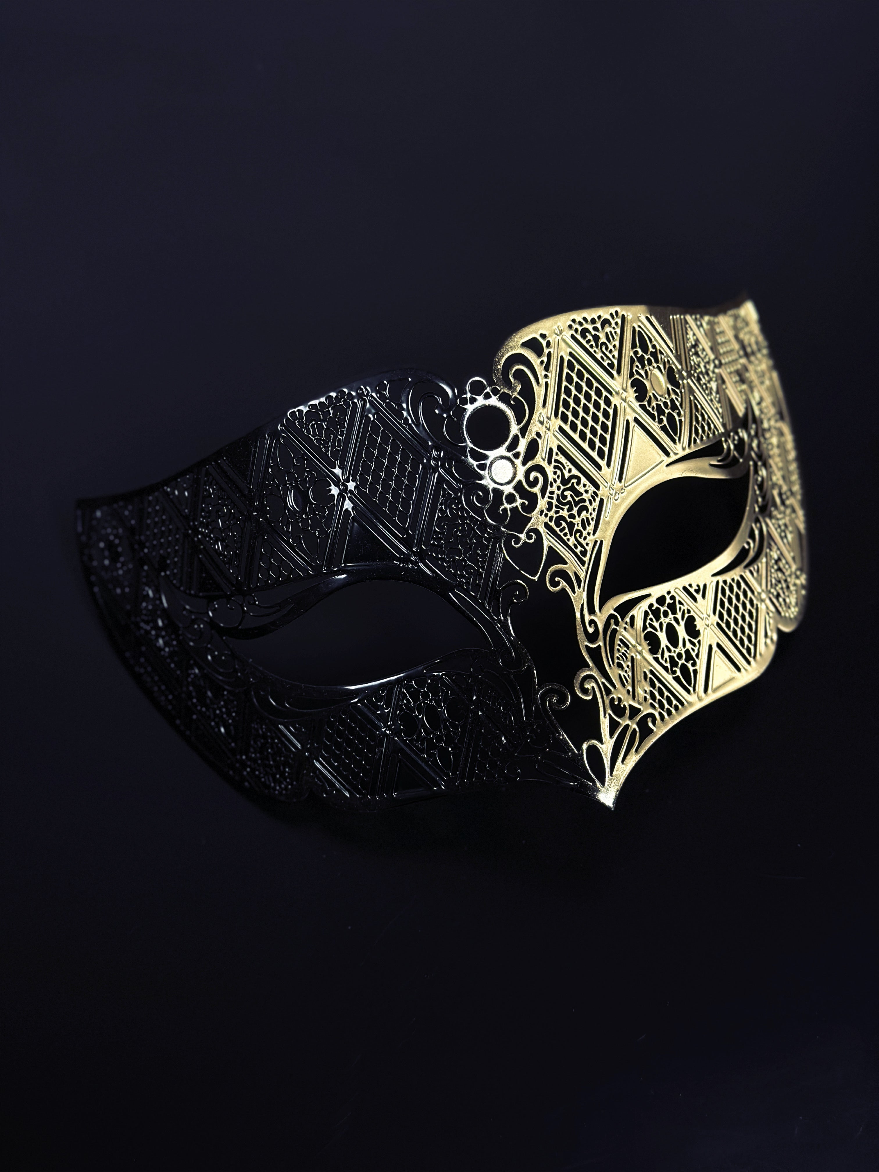 Men’s black and gold Venetian masquerade mask with geometric filigree design.