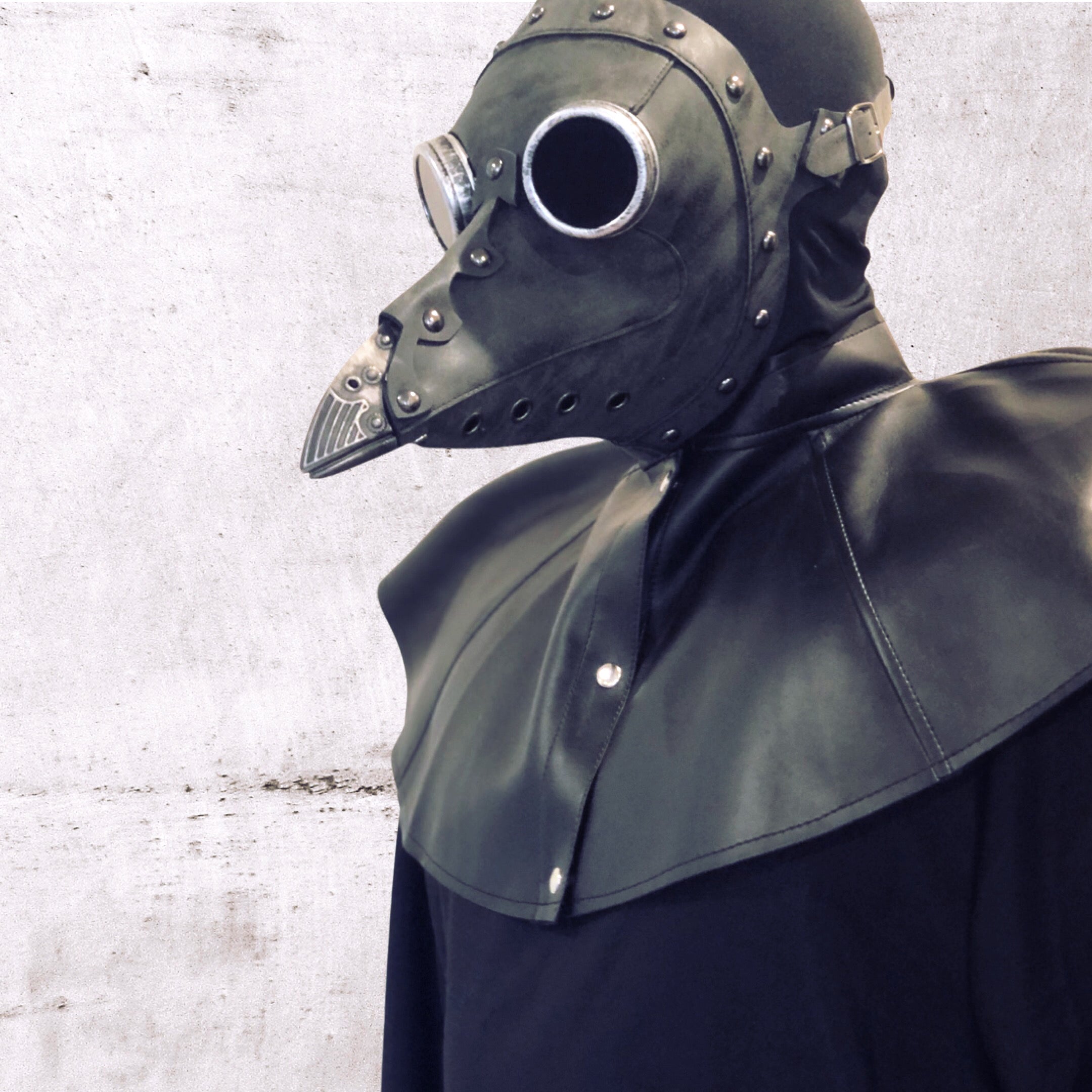 Gothic black costume mask featuring industrial plague doctor design and stitched leather detailing