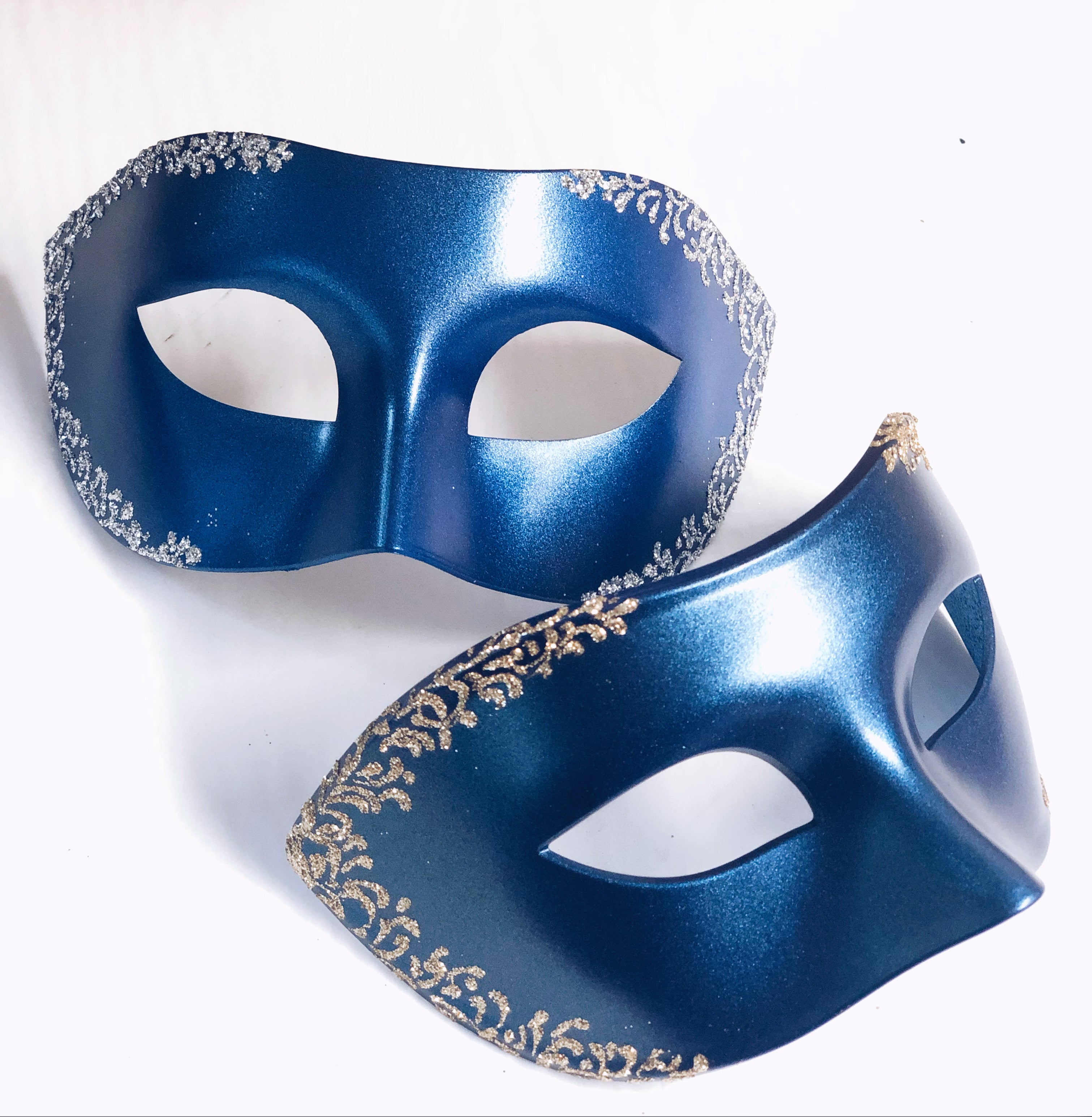 Metallic blue and gold couples masquerade mask set displayed on a white background