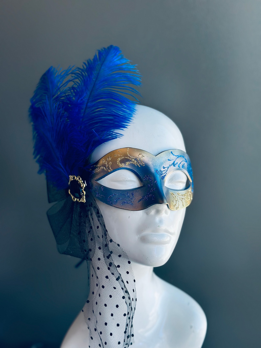 Blue and gold couples masquerade masks, men’s simple design, women’s mask with feather and dotted veil.