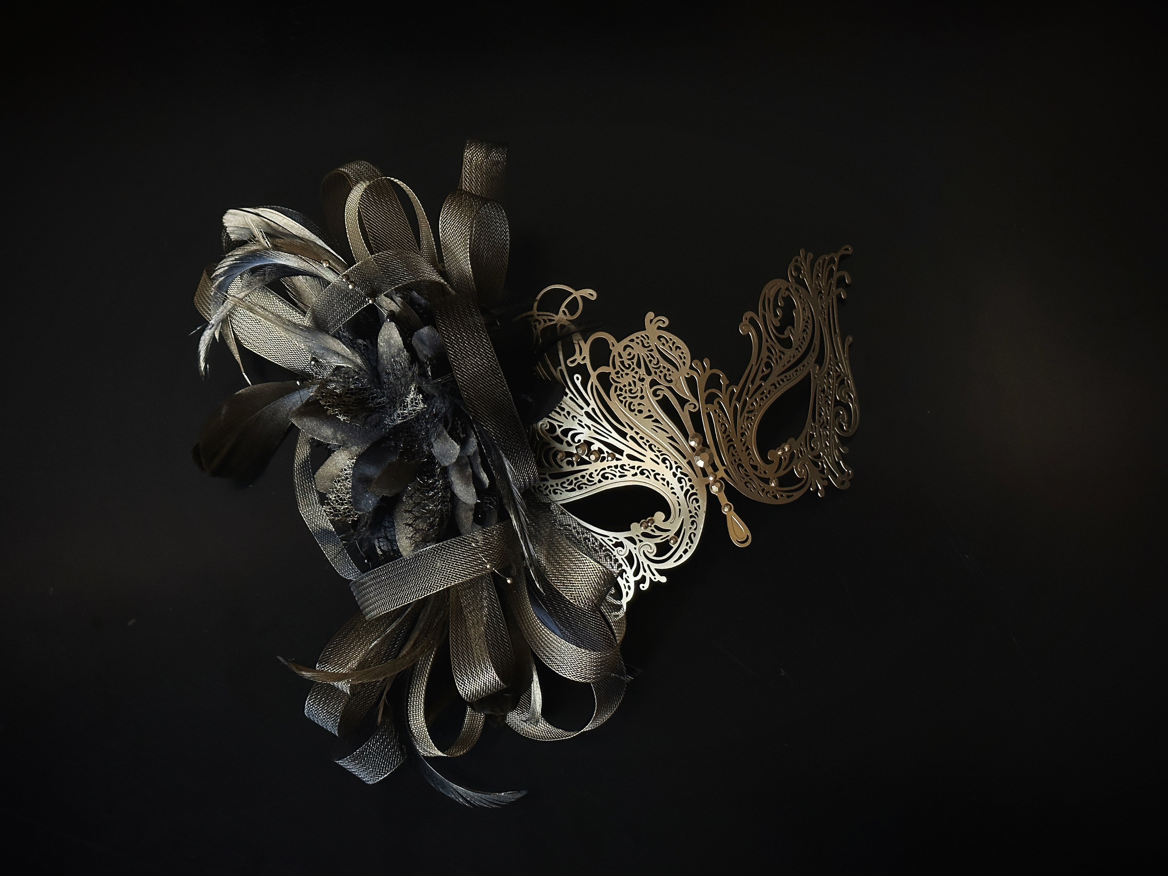 Gold and brown masquerade mask with filigree metal, tulle ribbon, and feathers, designed for proms and costume balls