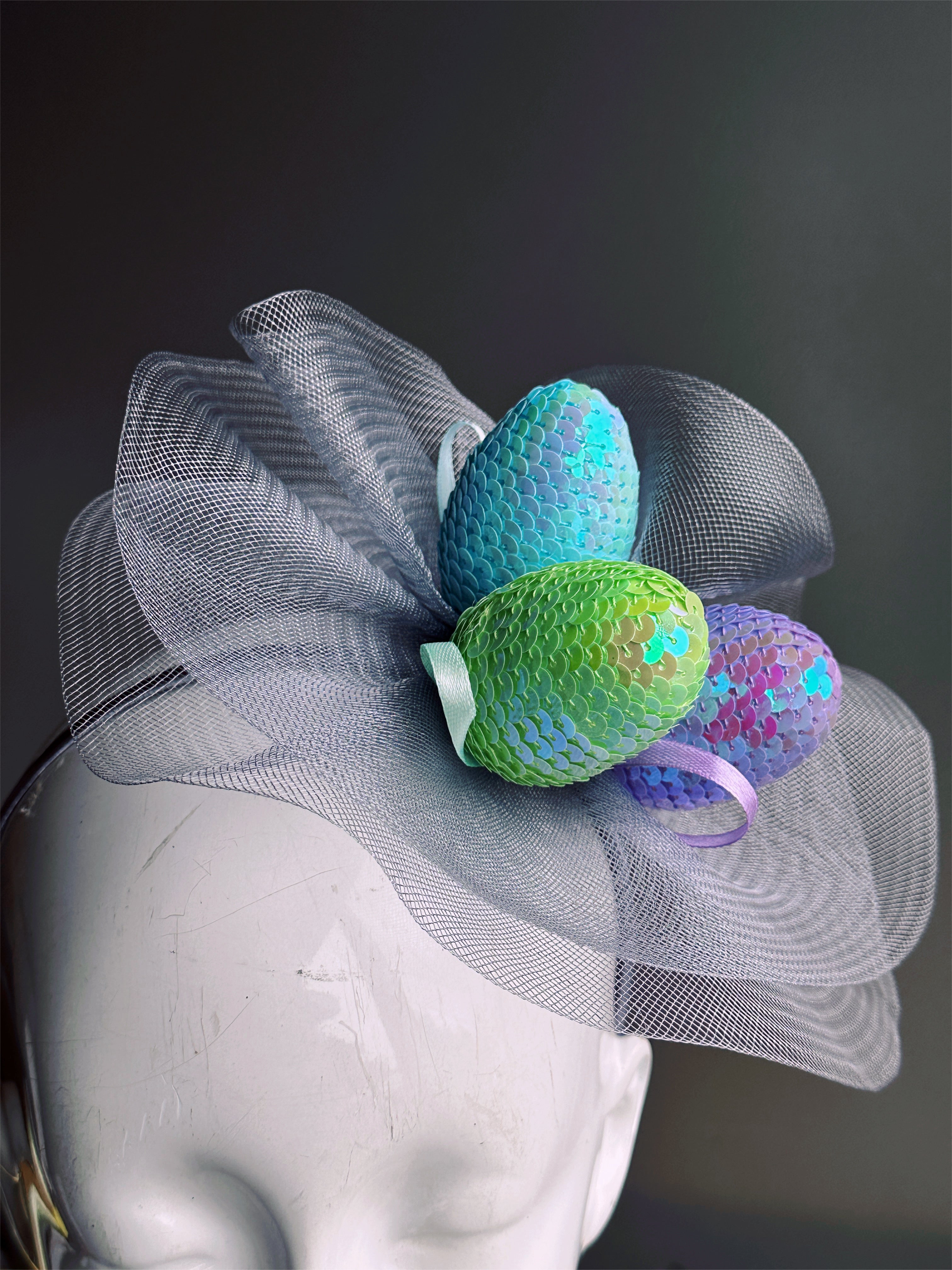 Mesh fascinator hat featuring iridescent pastel eggs on a headband