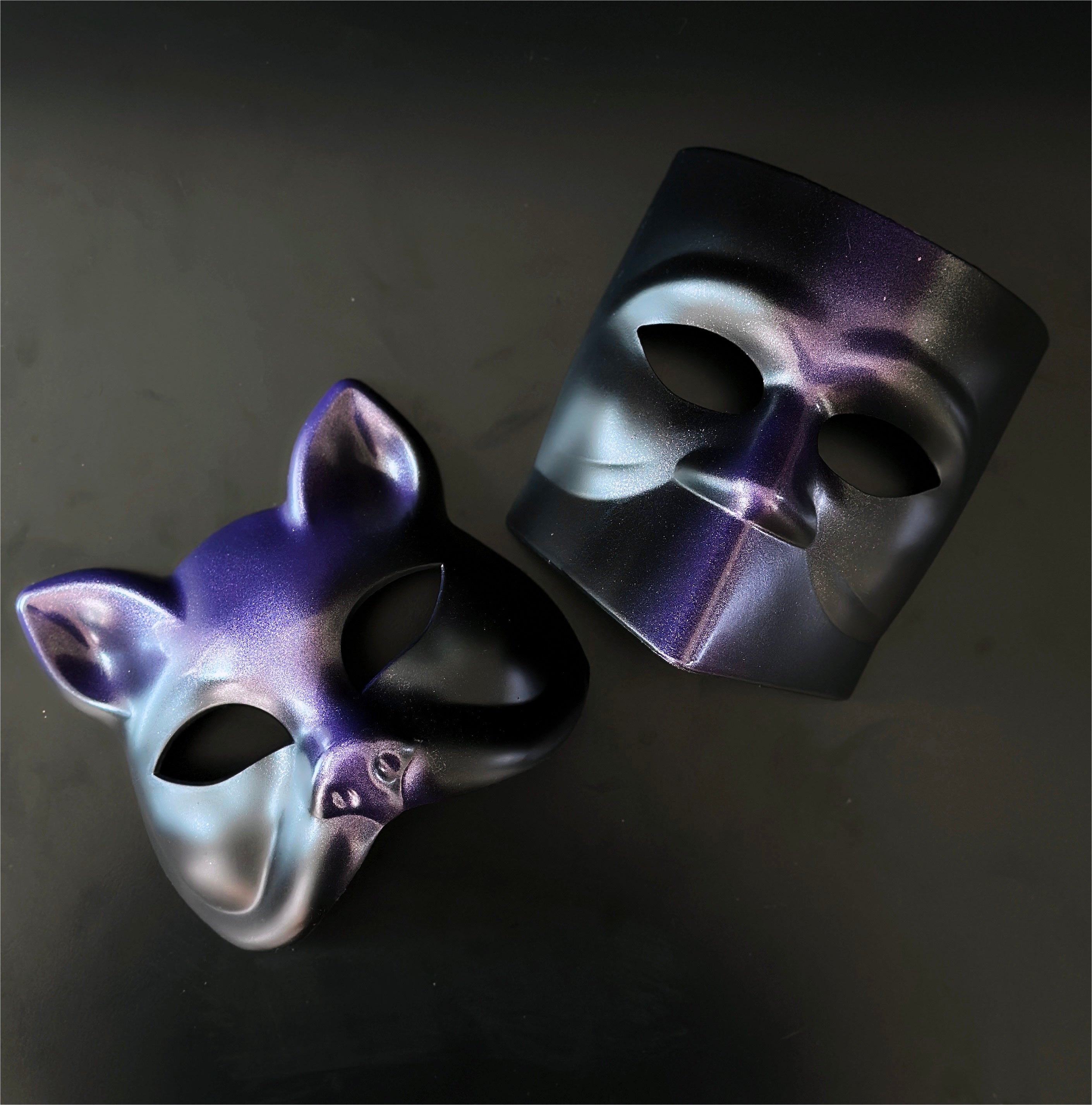 Purple and black dual-style masquerade mask set with cat and modern face designs for theatrical events.