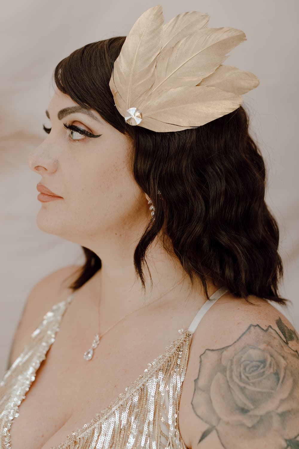 Elegant masquerade gold fascinator with feathers, tulle, and rhinestone detail