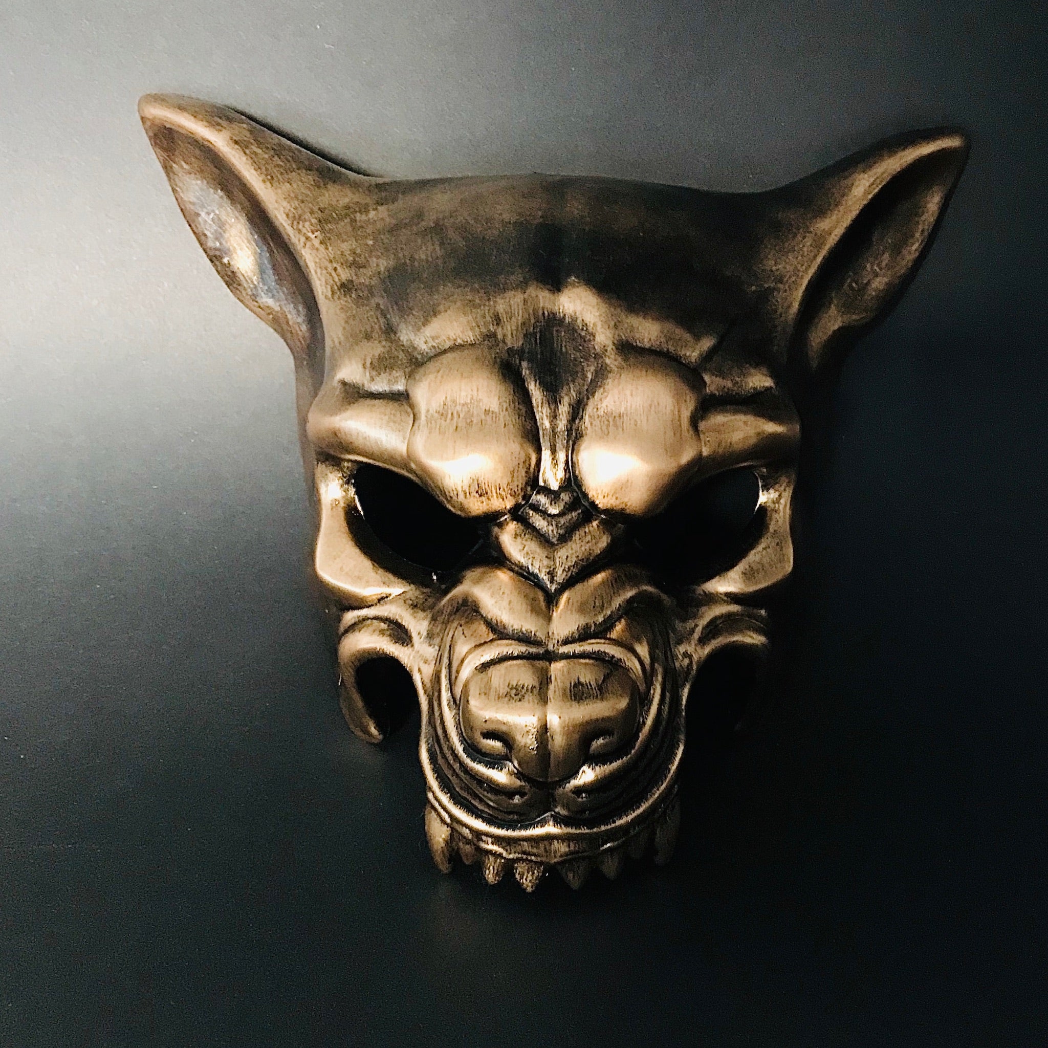 Metallic gold animal masquerade mask in a wolf design with sculpted features and dramatic presence