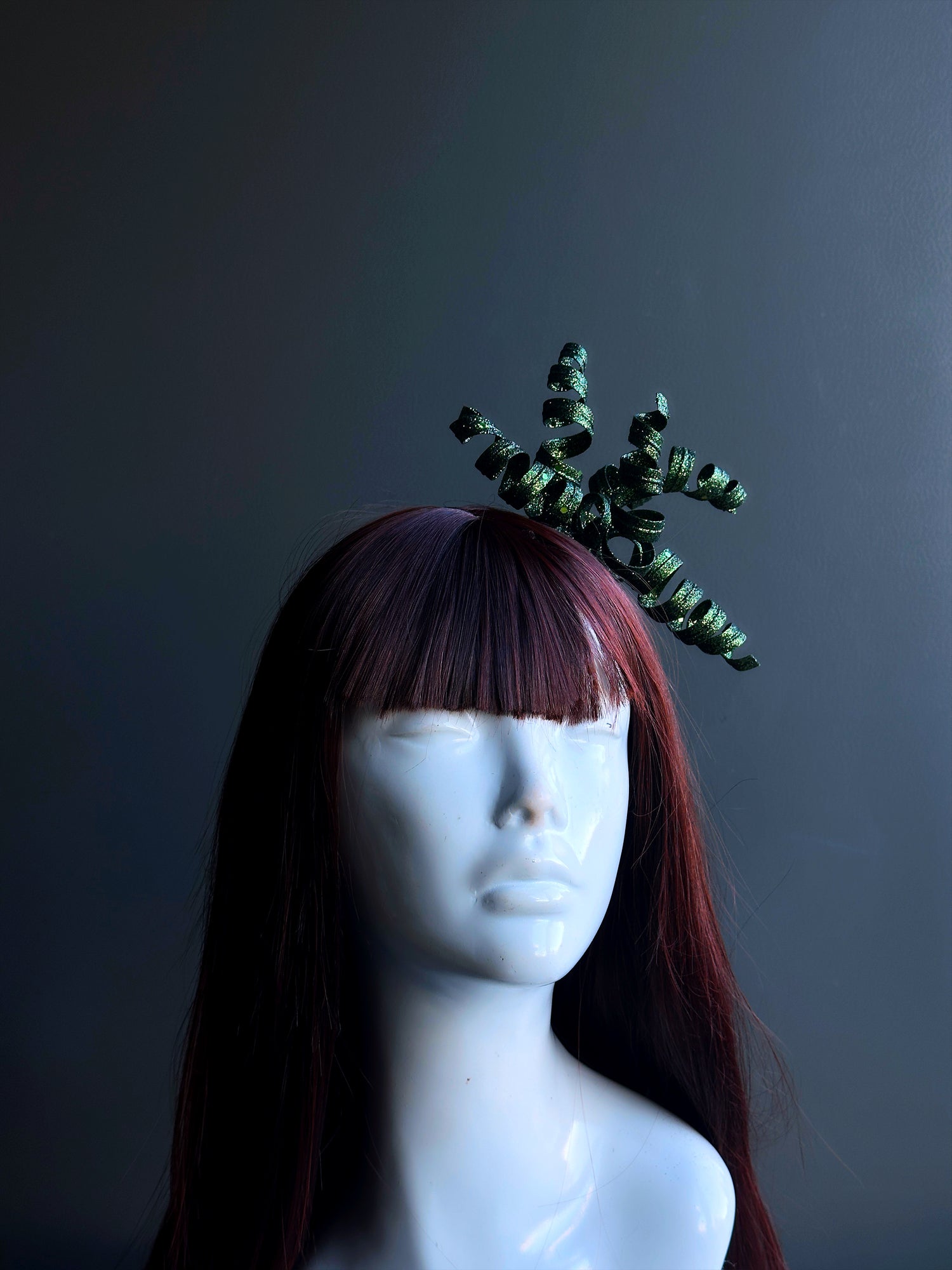 Unique green masquerade headpiece with twisted spirals and avant-garde flair