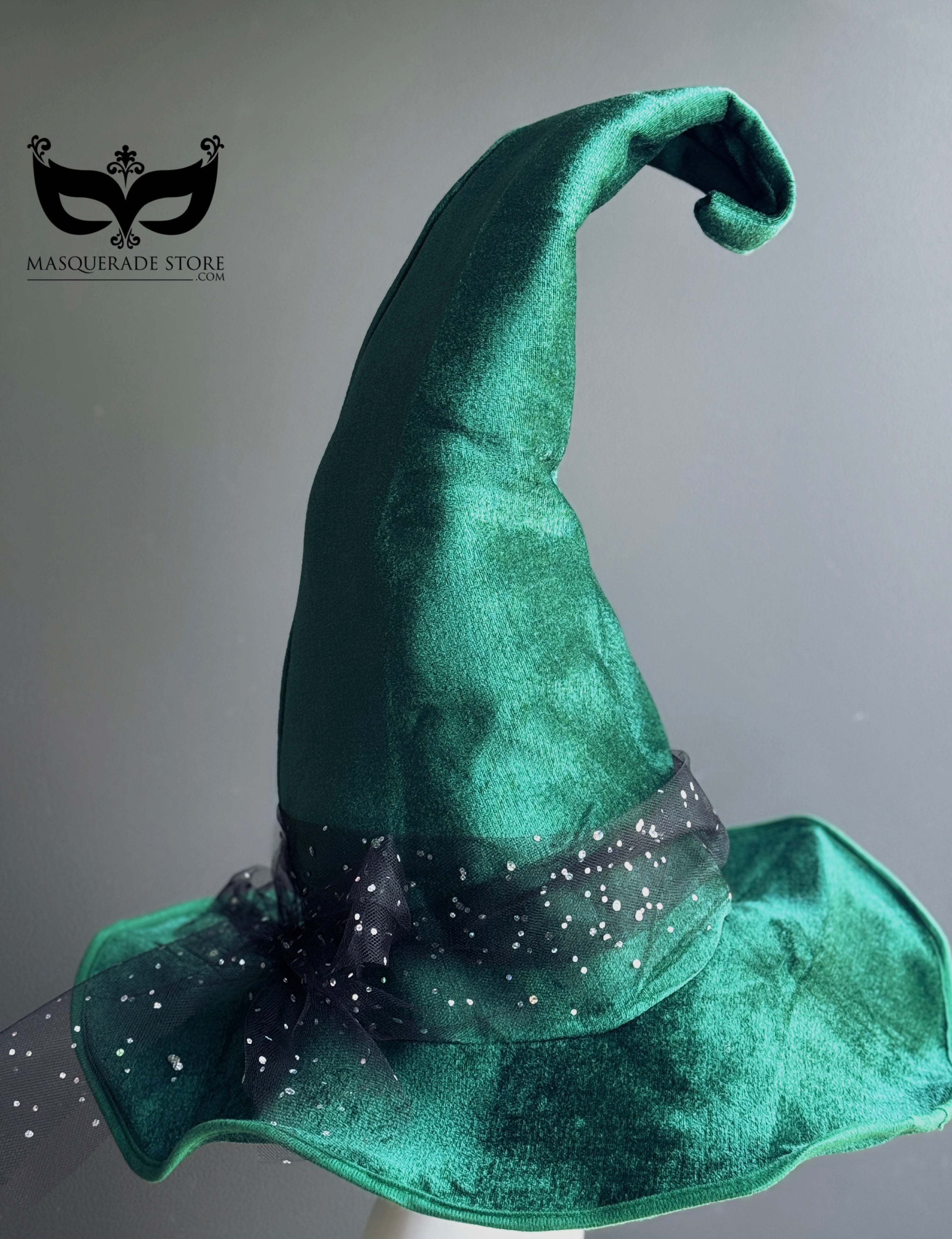Green witch hat, featuring a curled tip and sparkling starry tulle trim. Perfect for Halloween, witches balls, and masquerade parties, this enchanting hat brings whimsical elegance to any witch costume.