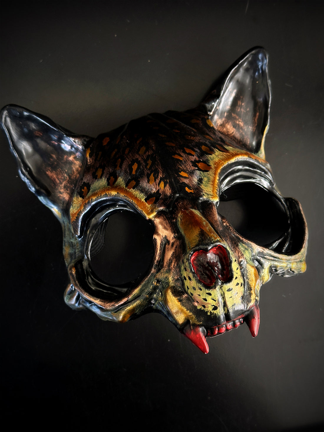 Jaguar-inspired masquerade mask with feline details and red fangs for Halloween or jungle costume parties.