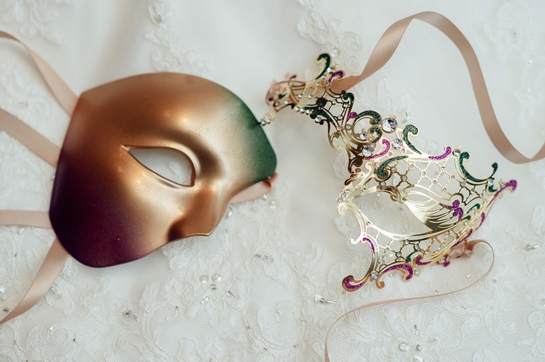 Mardi Gras couples masquerade mask set with ombre men’s mask in bronze, green, and plum, and ornate gold filigree women’s mask with glitter and rhinestones.