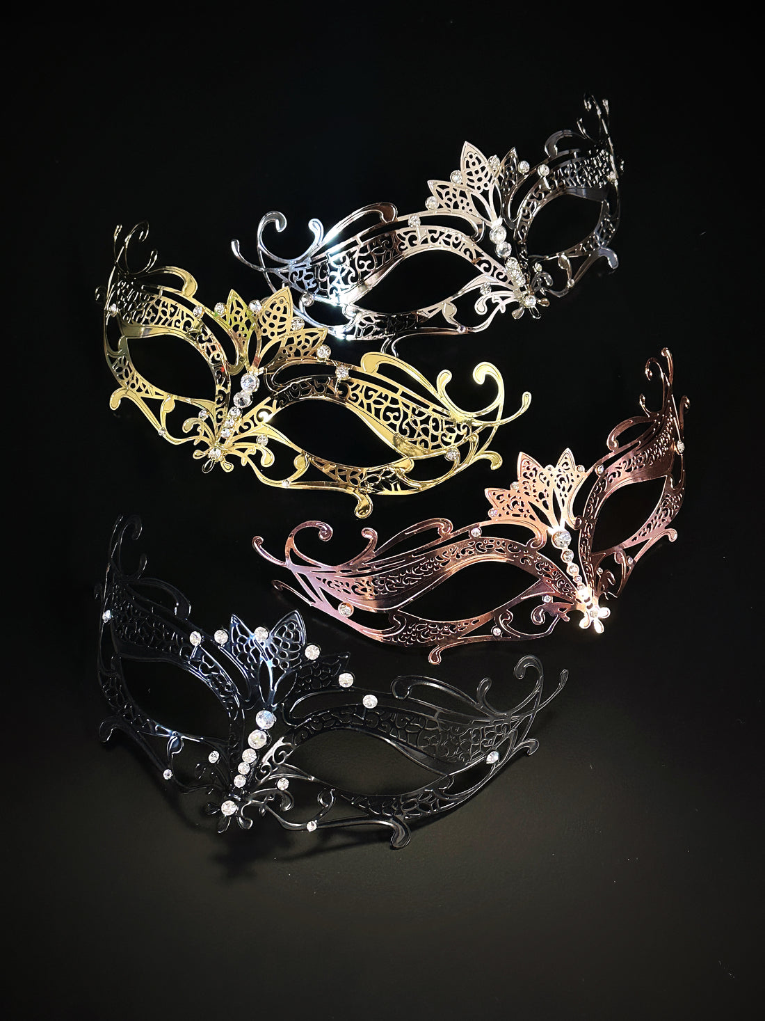 Metal masquerade masks in silver, gold, rose gold, and crystals.