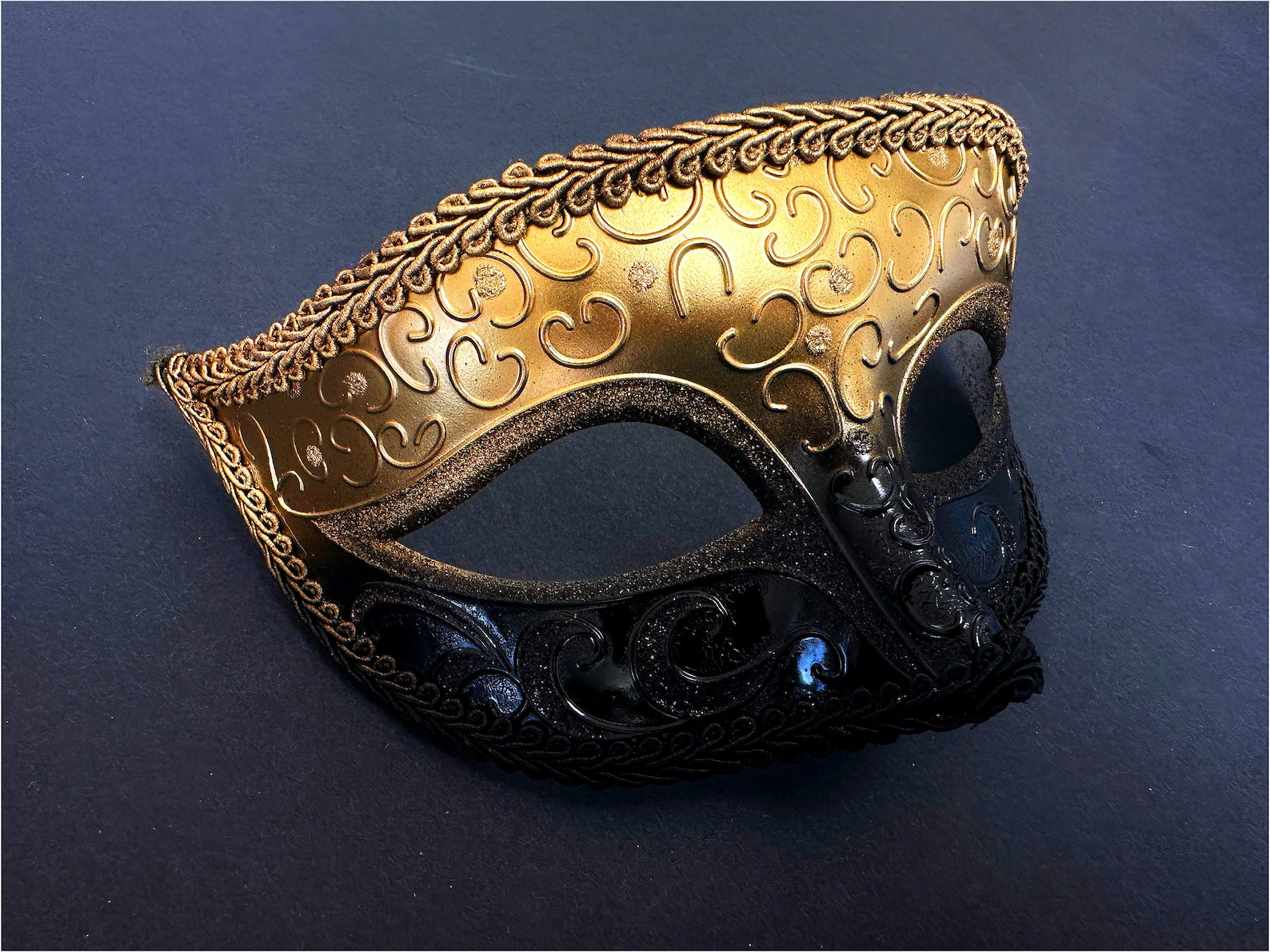 Men’s black and gold masquerade mask with ornate scrollwork and a bold Venetian design.