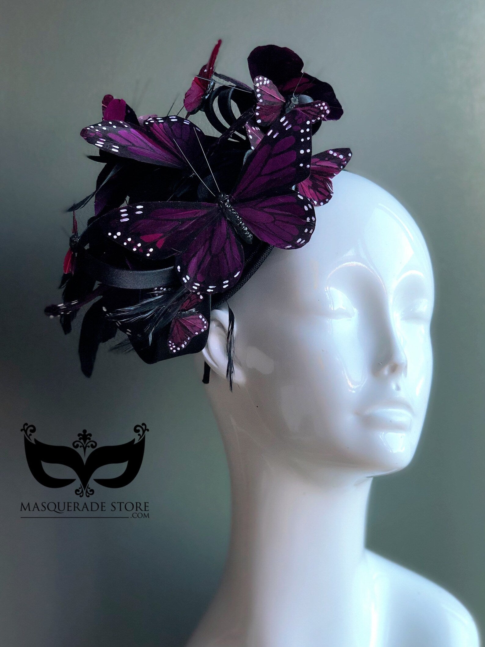 Whimsical headpiece featuring vibrant purple butterflies arranged on a sculptural black fascinator