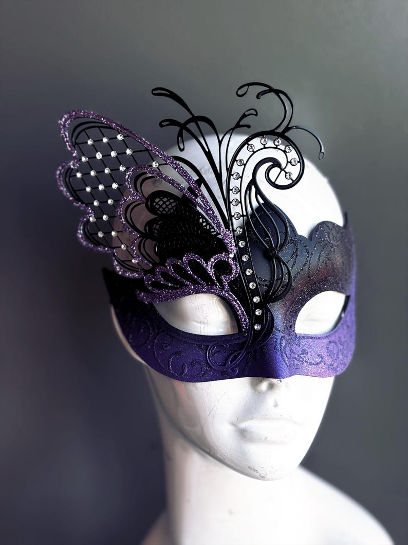 Purple and black butterfly masquerade mask with rhinestone wing design.