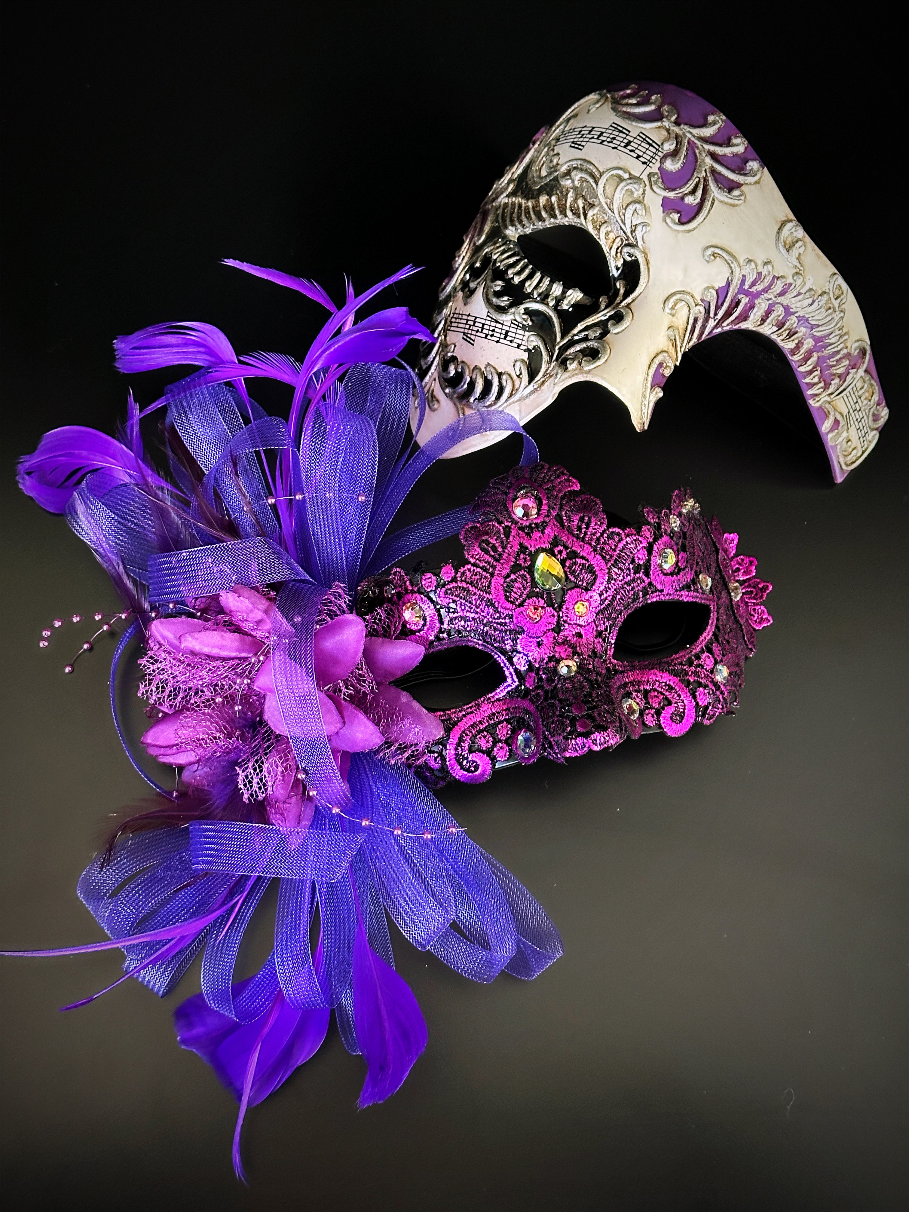 Couples masquerade mask set featuring purple feathered mask for women and white sculpted skull mask for men
