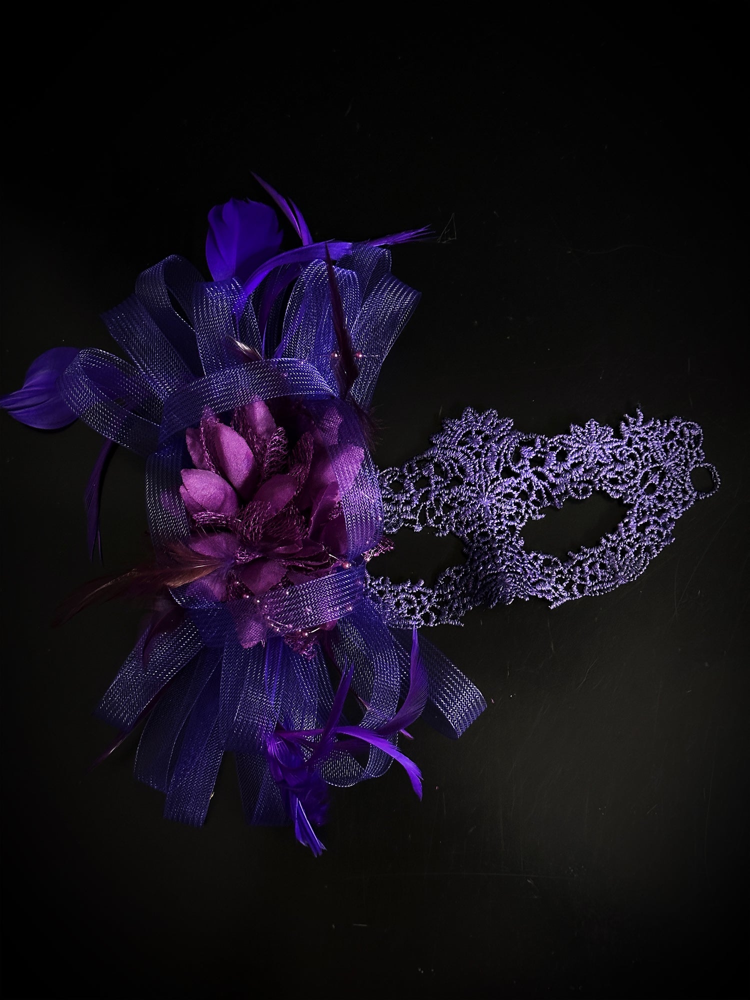 Purple lace masquerade mask with feathers, floral accent, and tulle, ideal for prom, masquerade ball, or Halloween.