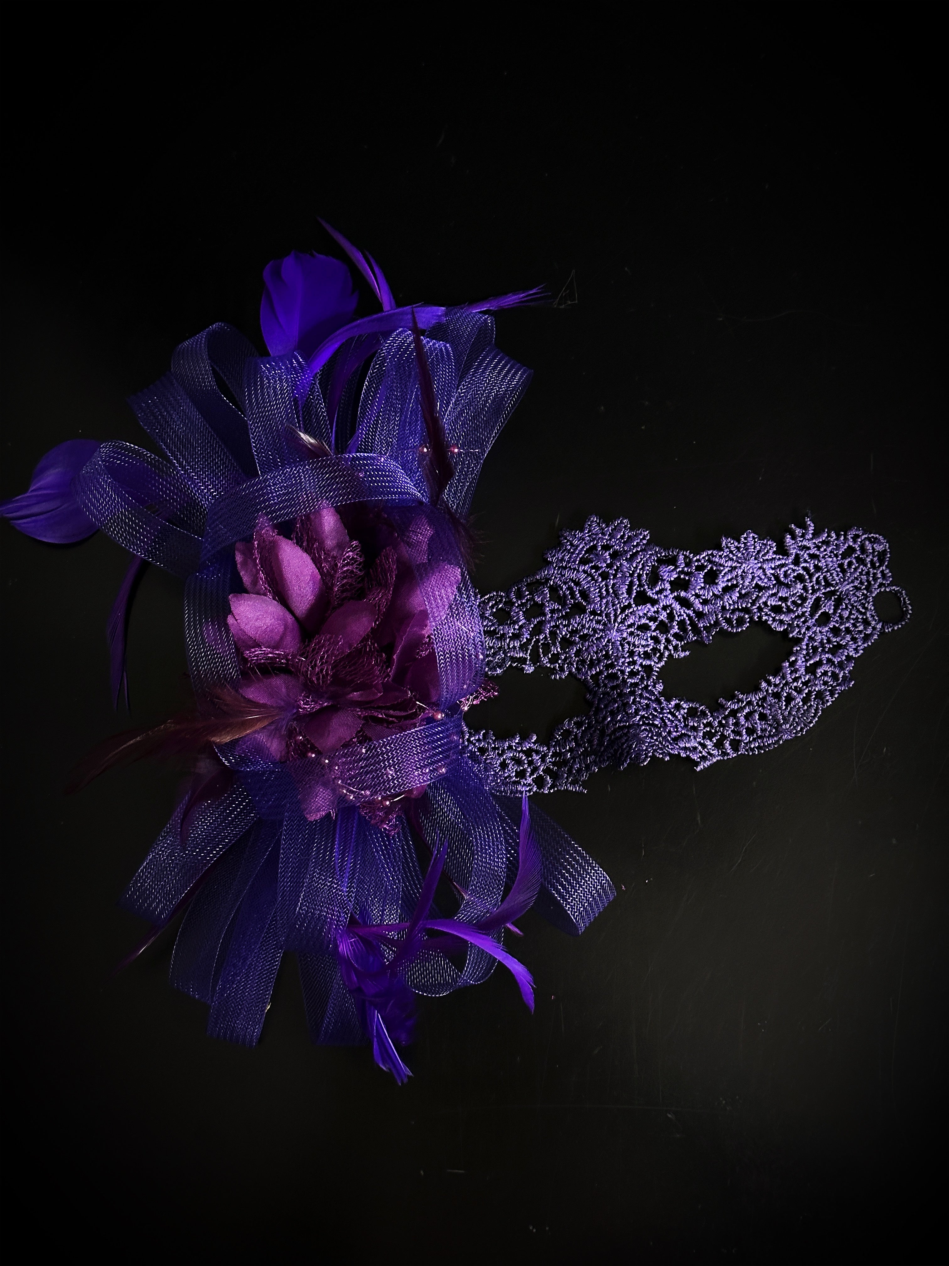 Purple lace masquerade mask with feathers, floral accent, and tulle, ideal for prom, masquerade ball, or Halloween.
