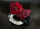 Sugar skull masquerade mask decorated with red and black roses, spiderweb detail, and a floral gothic crown.