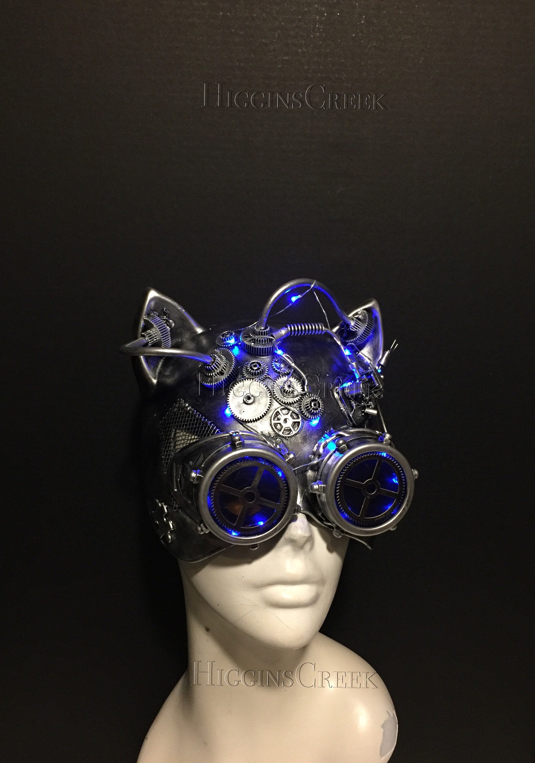 Silver steampunk cat masquerade mask with purple LED lights and mechanical goggles