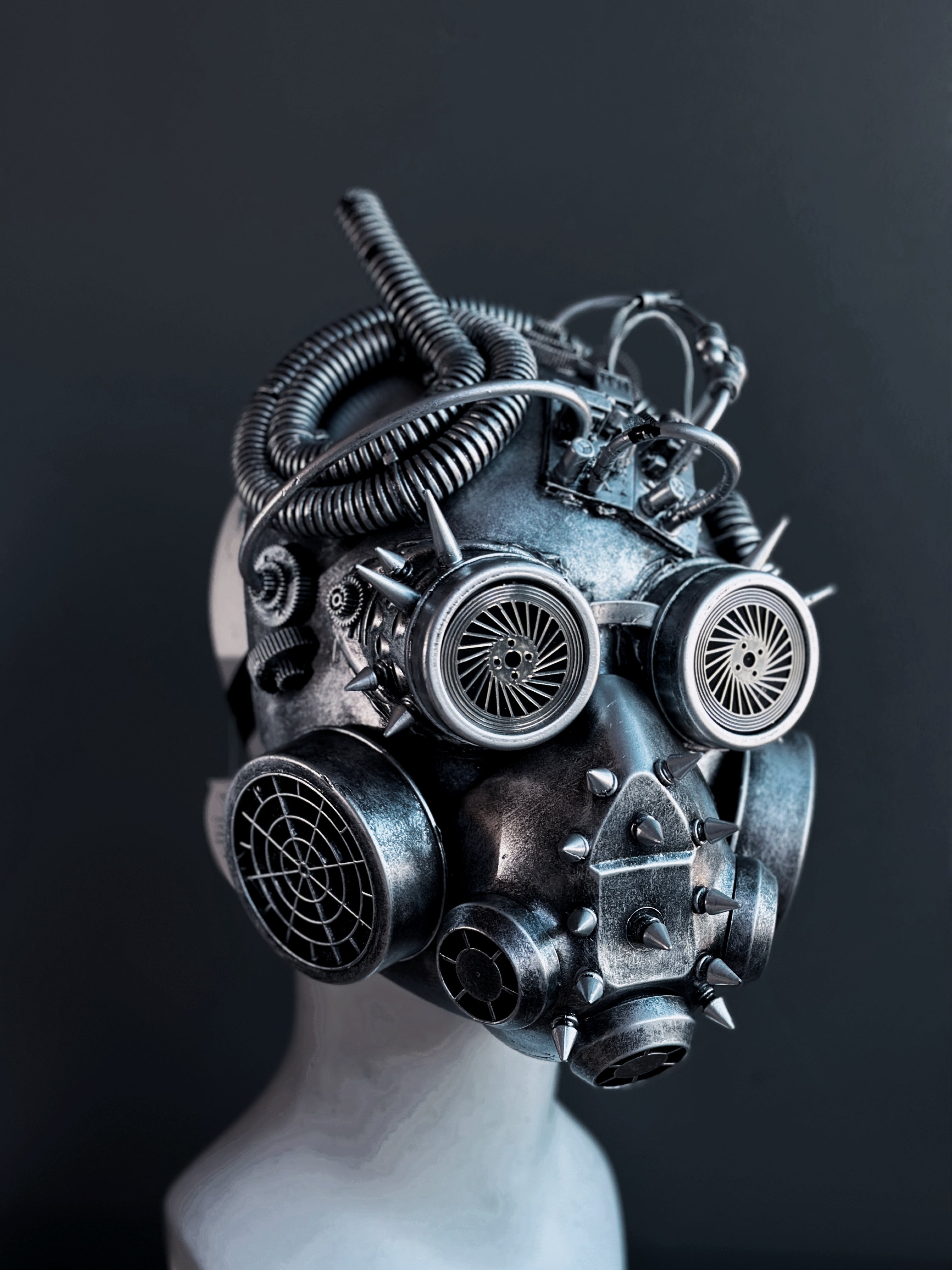 Metallic industrial-style steampunk helmet featuring spikes, vents, and sculpted tubing for dystopian costume wear