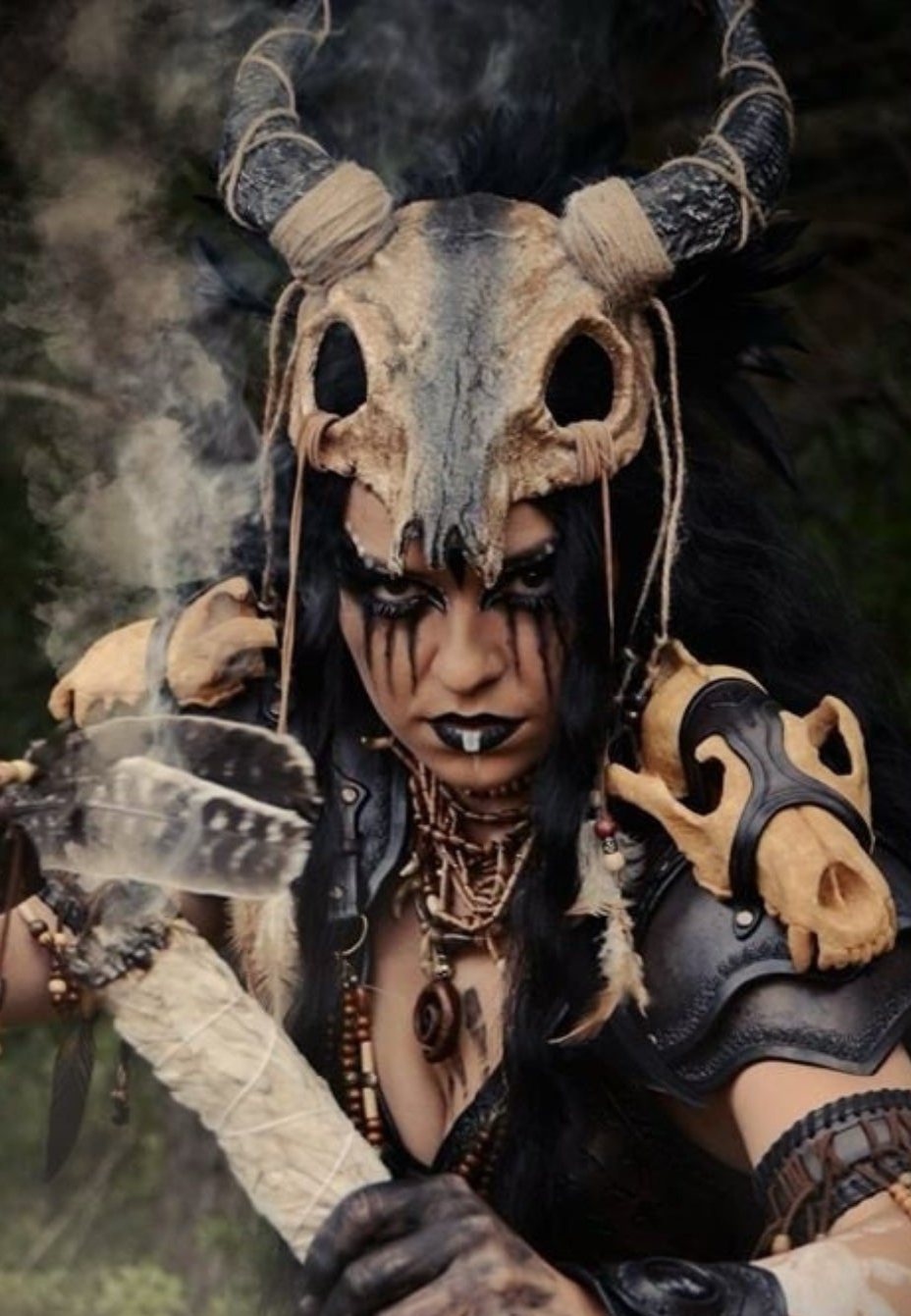Tribal costume headdress with skull centerpiece, black horns, and ritual warrior styling worn with dramatic makeup