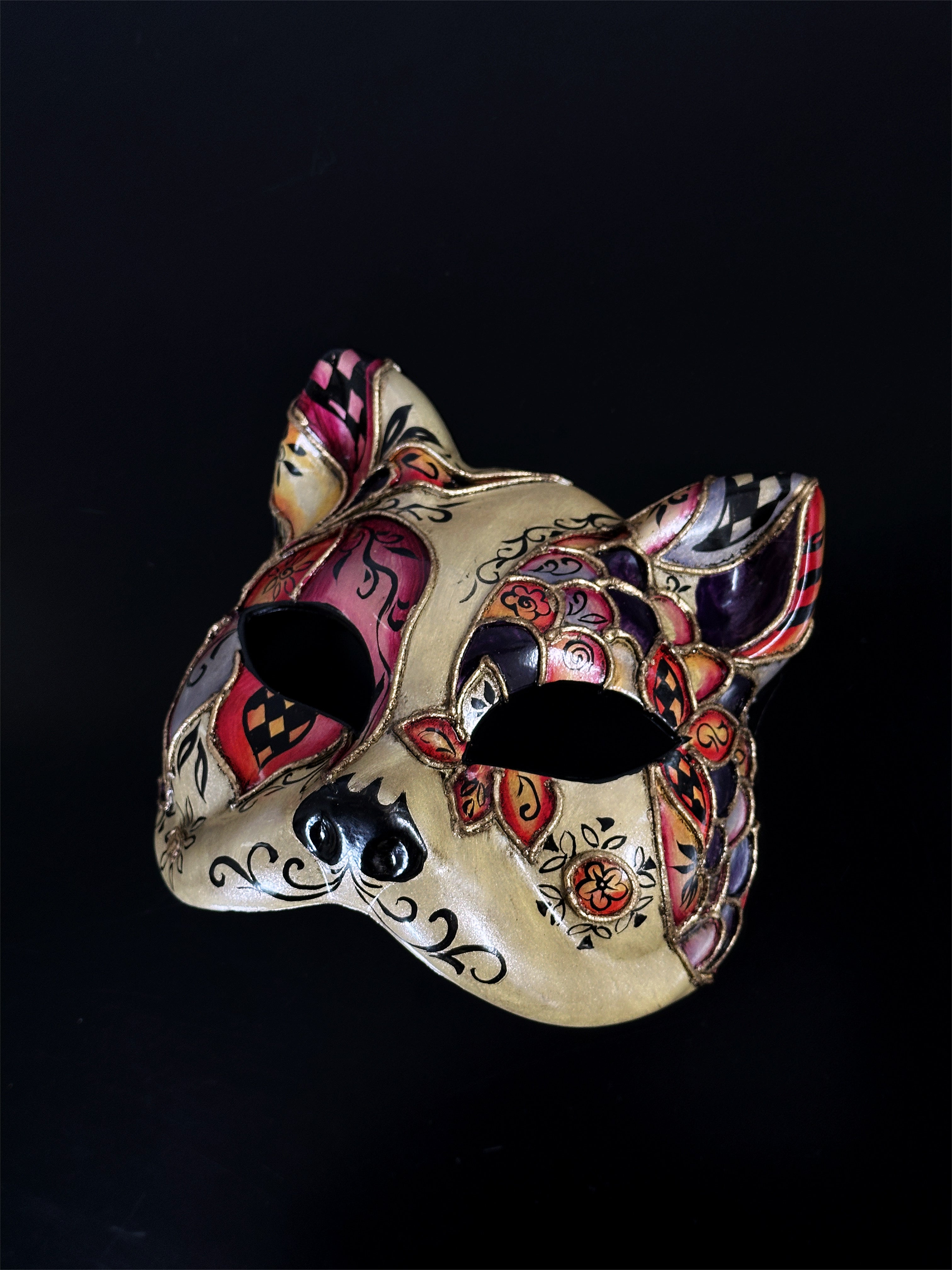 Venetian gold cat masquerade mask with colorful harlequin designs for Carnival, Halloween, or masquerade balls.