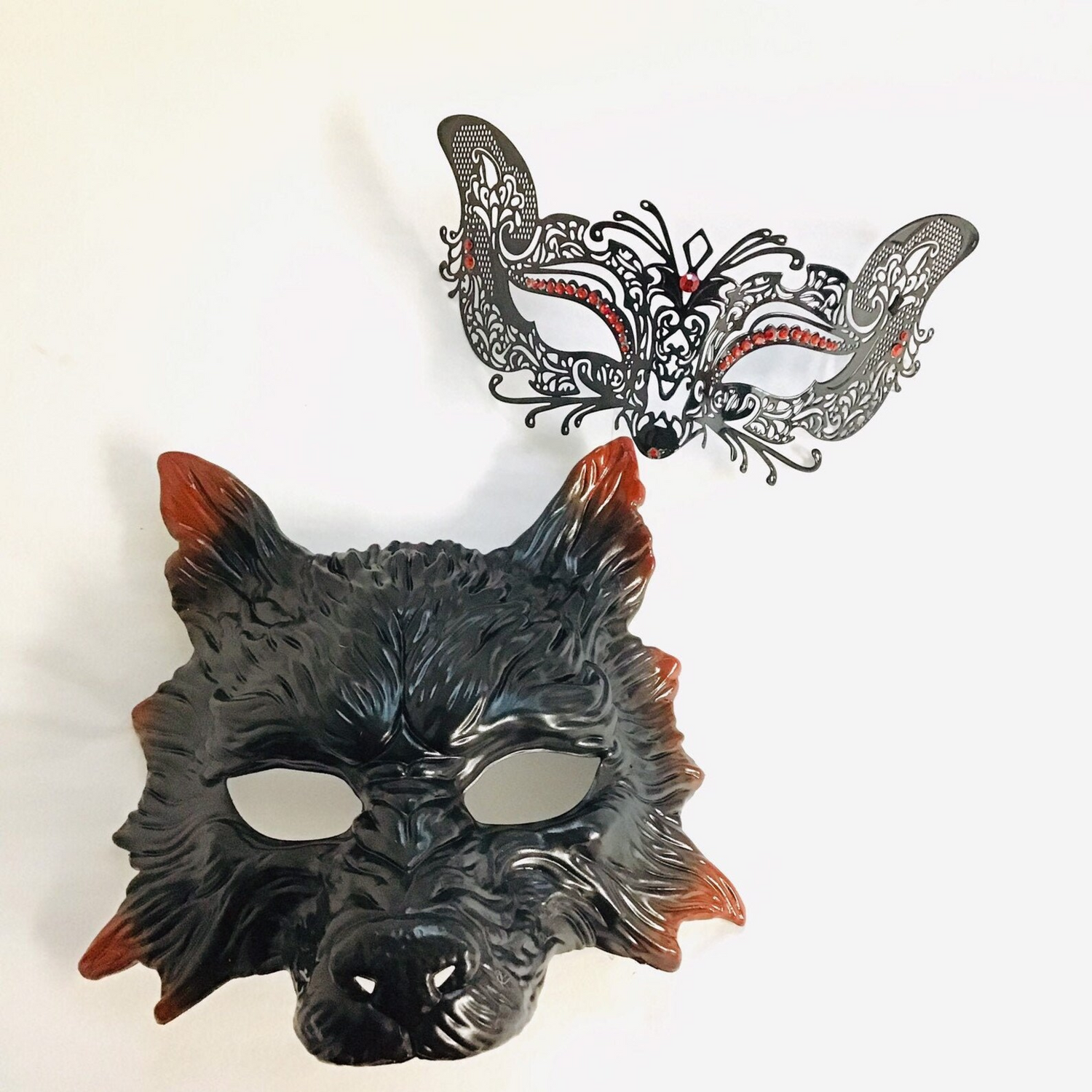 Wolf and kitty masquerade mask set with a black wolf mask for men and a lace bunny mask with red rhinestones for women.