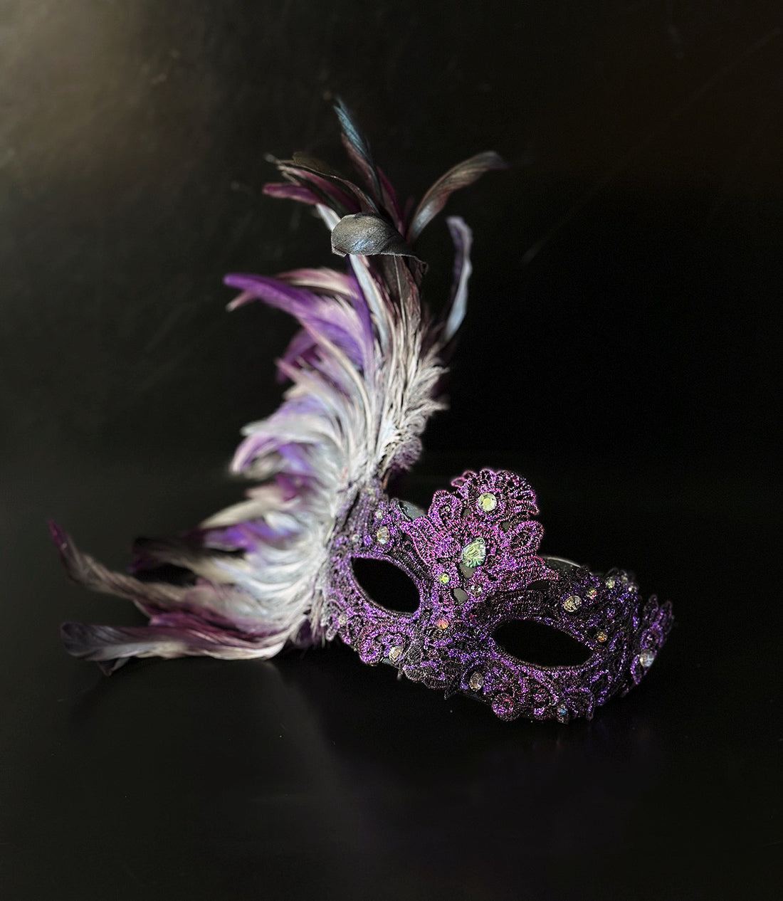 Purple feather masquerade mask with ornate resin half mask for formal masquerade occasions.