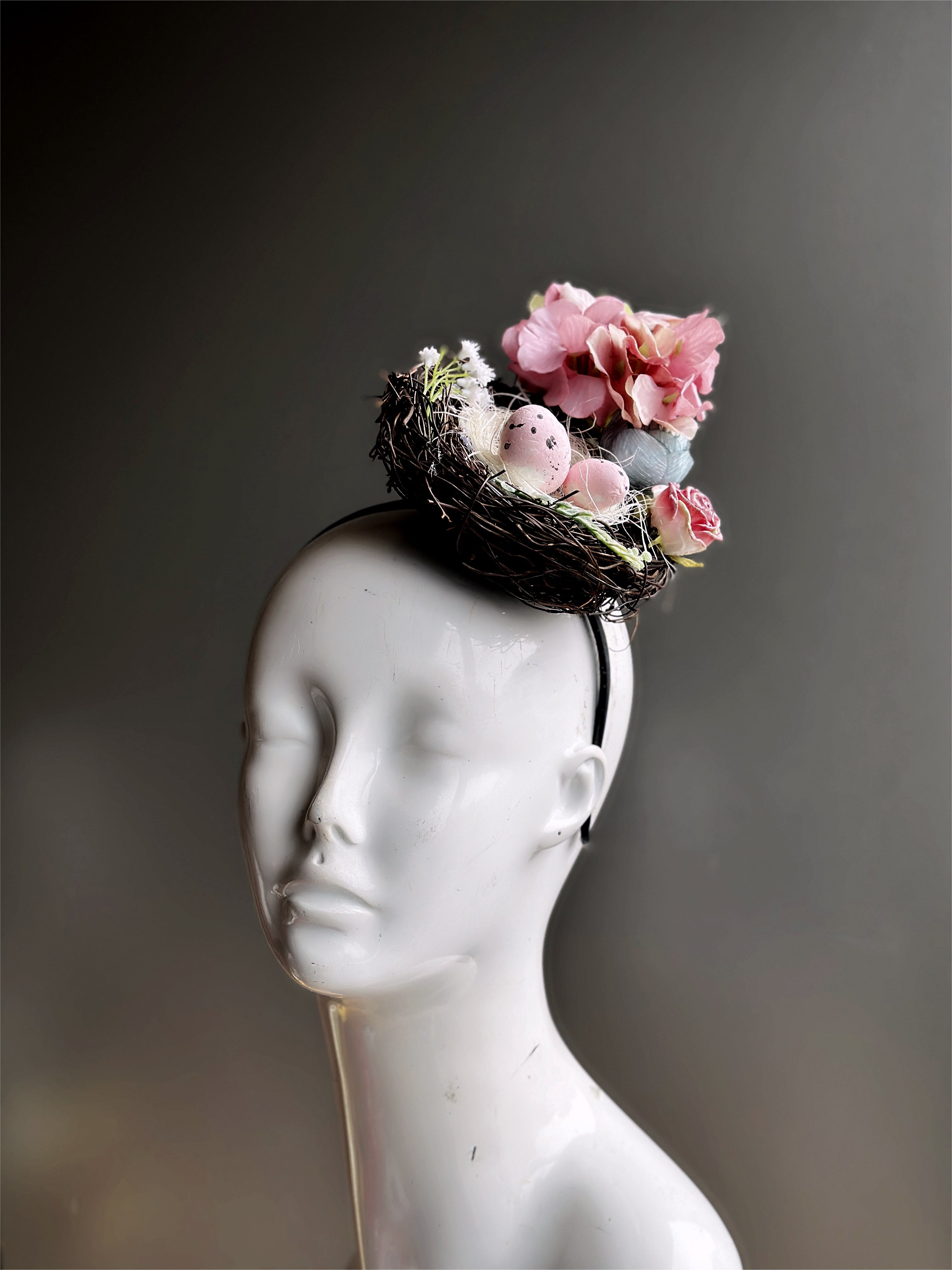Easter Fascinator Hat in Bird nest design with pink eggs and blue and pink flowers.