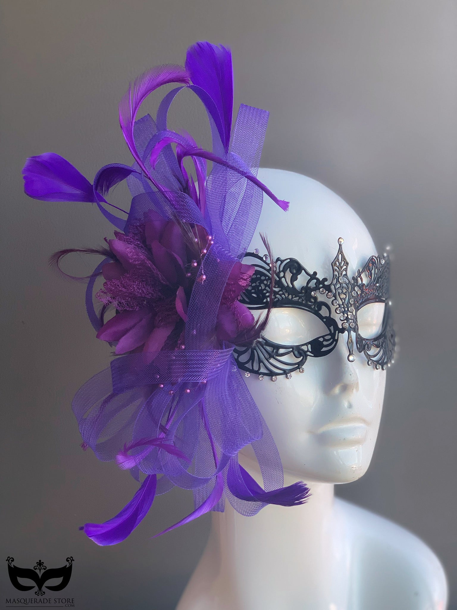 Ana Metal Mask in black with intricate filigree, purple tulle accents, and elegant feather details for formal occasions.