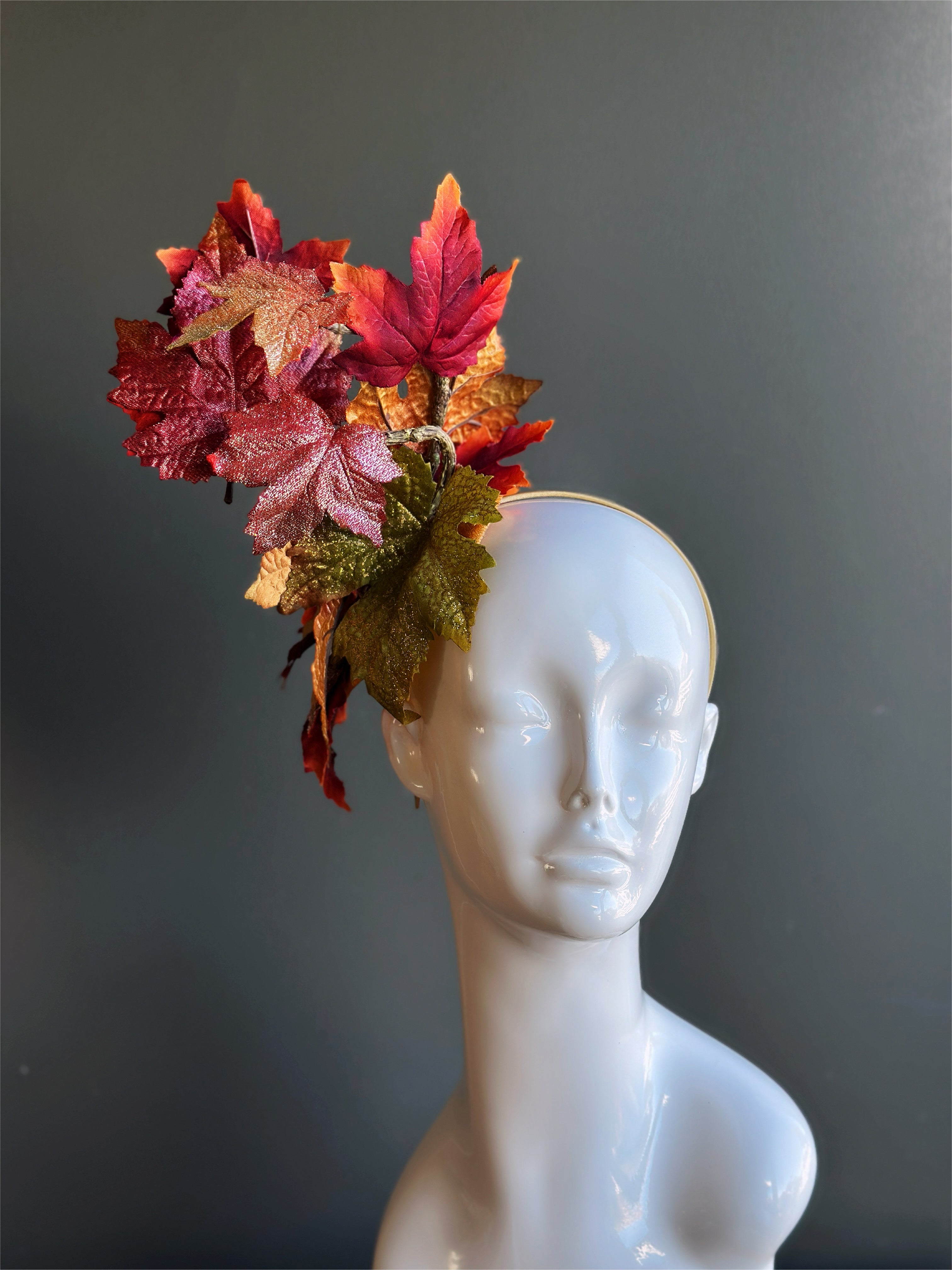 Autumn leaf fascinator hat with glittered red and gold leaves for fall.