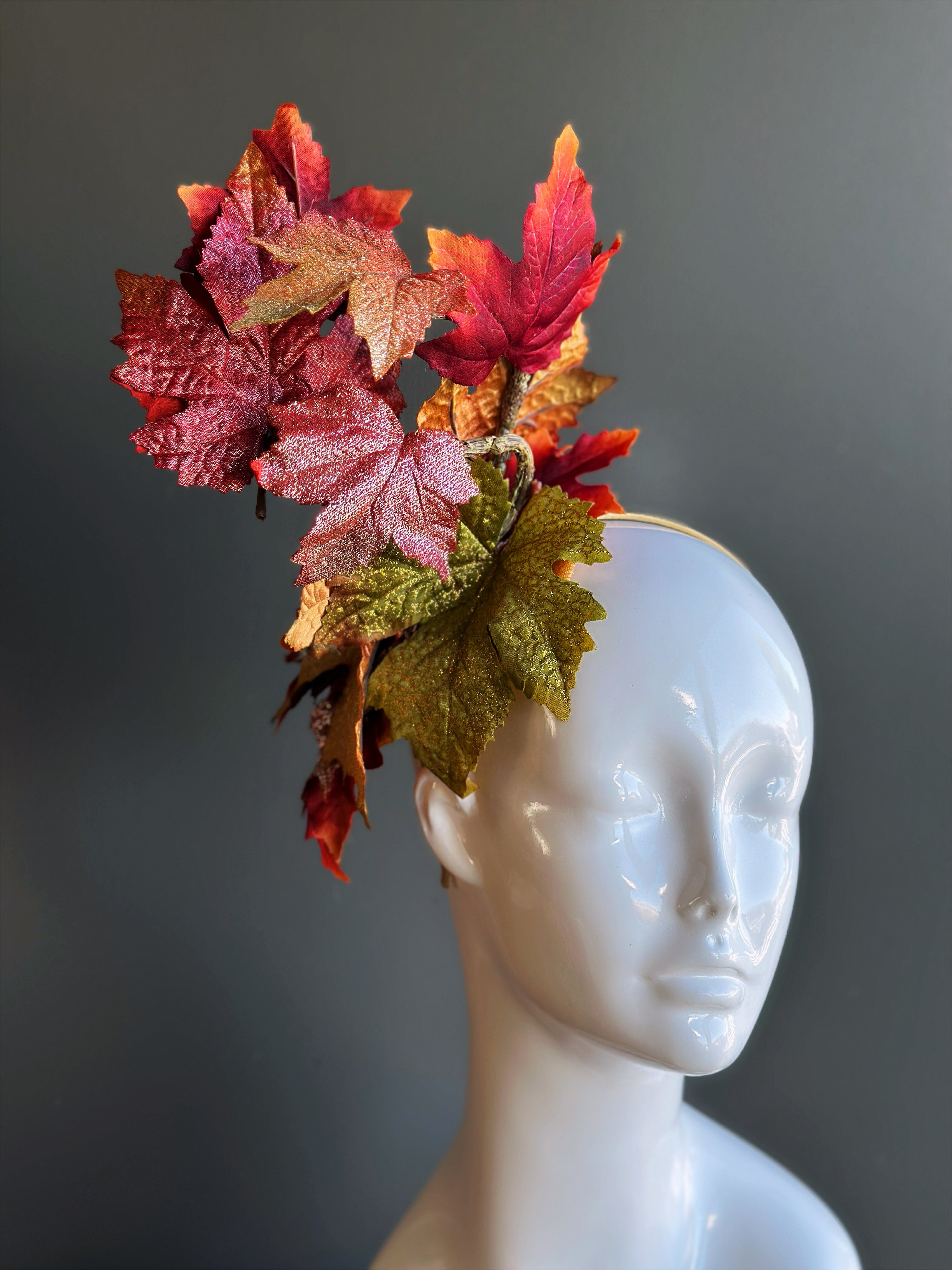 Autumn leaf fascinator hat with glittered red and gold leaves for fall.