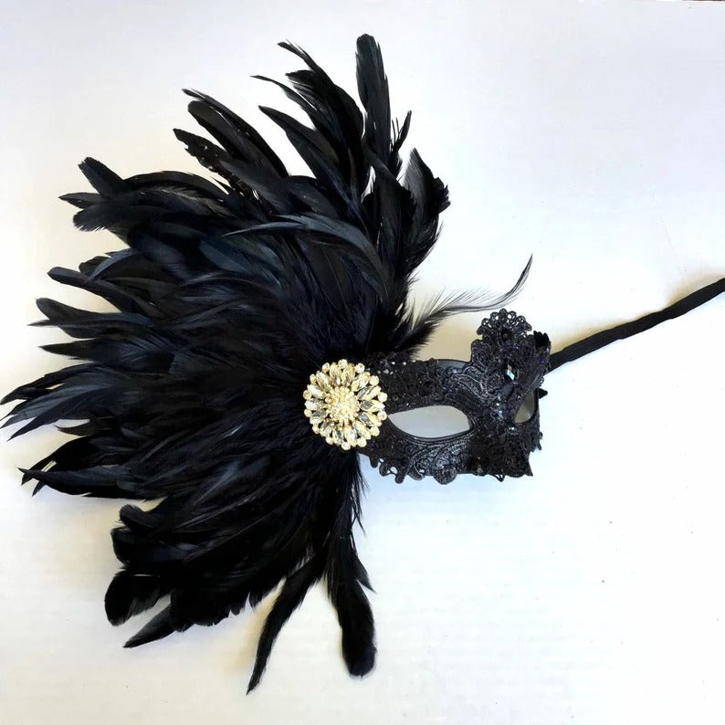 Luxurious black masquerade mask with feather accents and crystal brooch, perfect for proms, balls, and Venetian-inspired events.