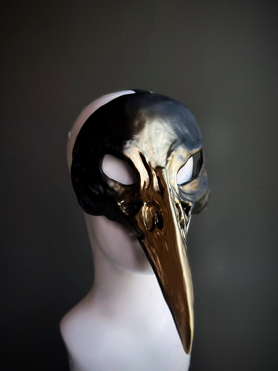 Black and gold bird mask with a sleek black upper and metallic gold accents, perfect for masquerades and gothic events.