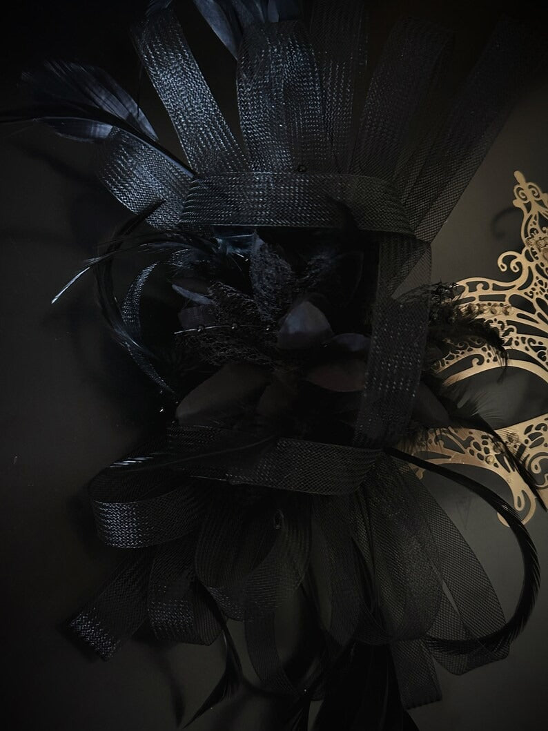 Elegant black and gold masquerade mask with feathers and filigree lace metal for women, perfect for Venetian balls and proms.
