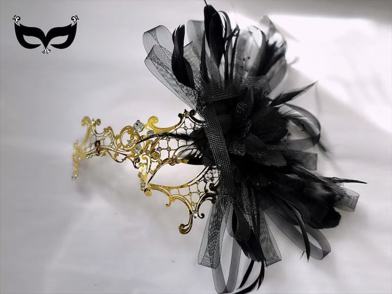 Elegant black and gold masquerade mask with feathers, ribbons, and rhinestones, perfect for Venetian balls, parties, and proms.