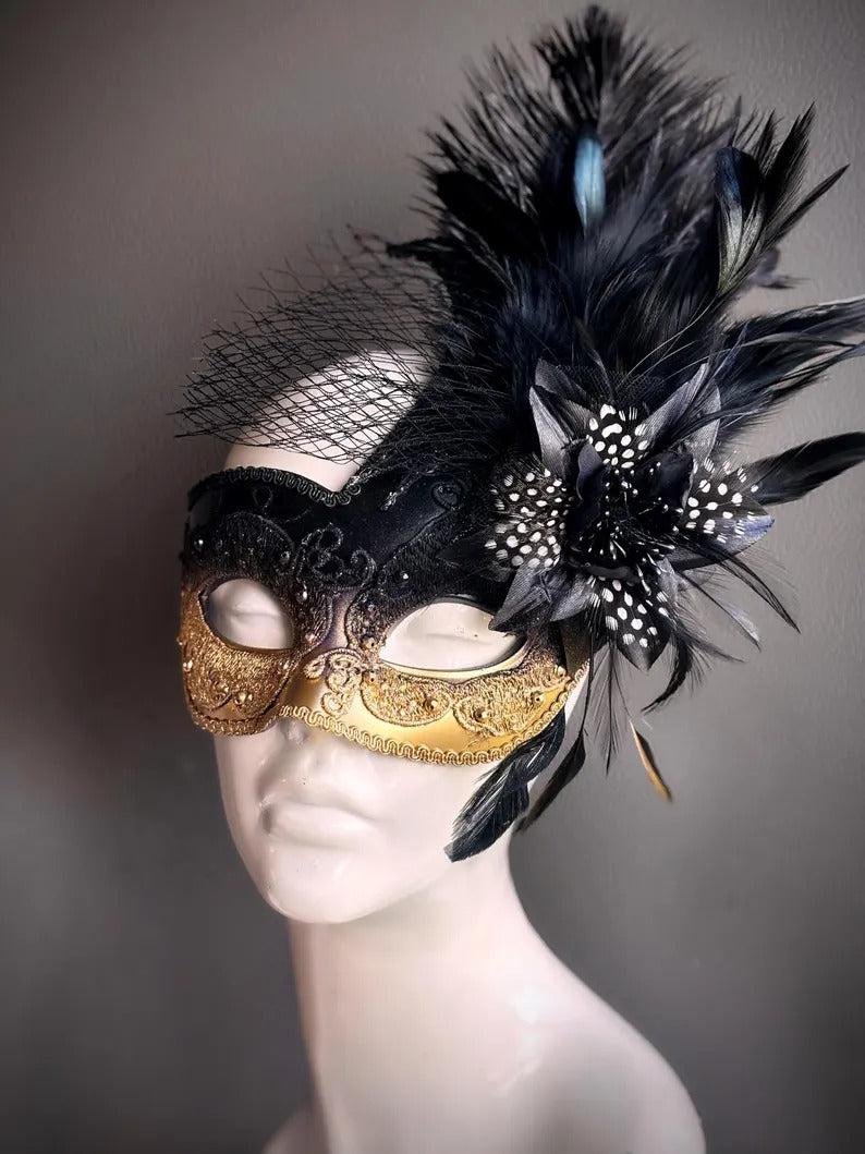 Elegant black and gold masquerade mask with feathers and netting, perfect for proms, balls, and Venetian parties.