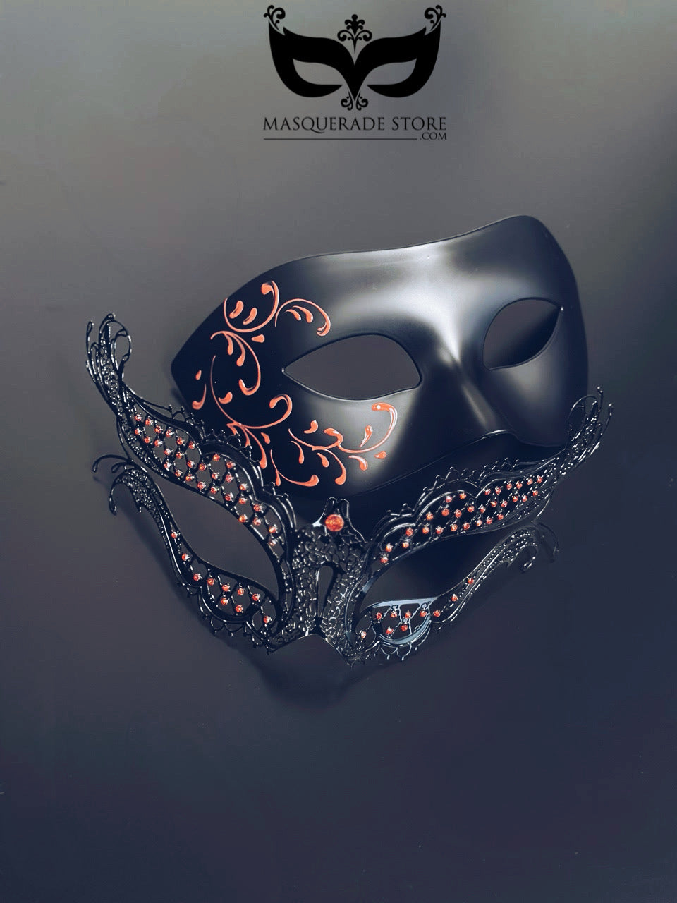 Black and red masquerade mask set with black matte filigree mask for men and black metal mask with red rhinestones for women.
