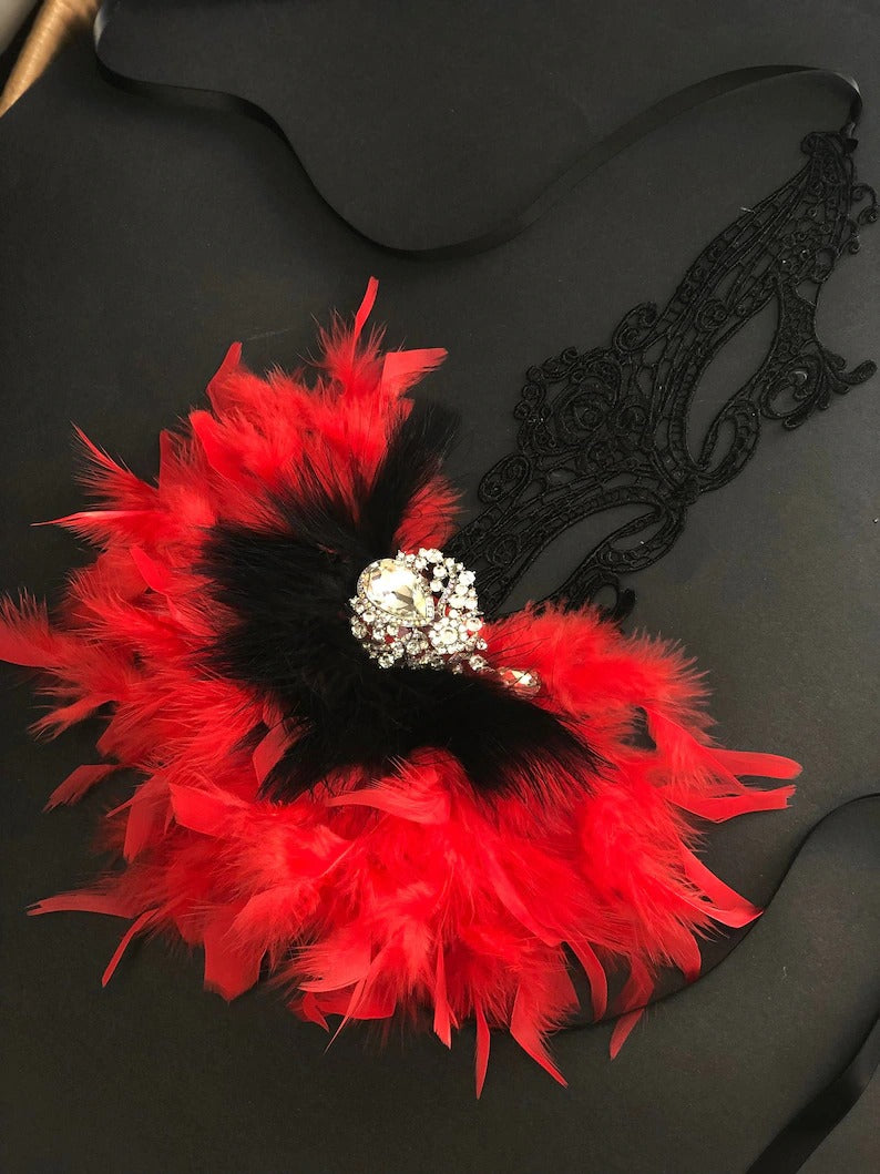 Black lace masquerade mask with red and black feathers and rhinestone detail