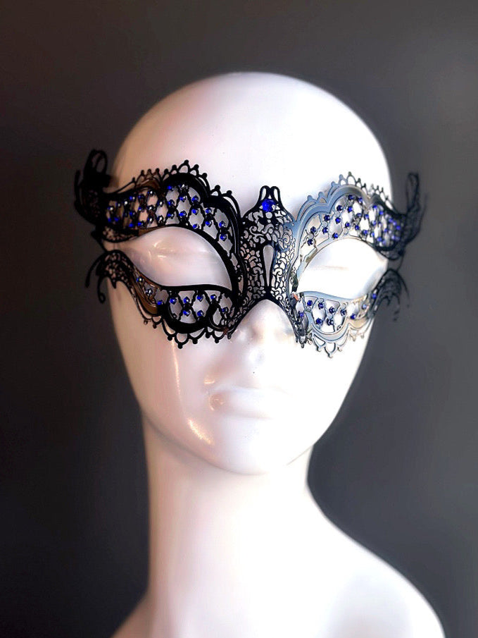 Black and silver metal mask with intricate cutouts and blue rhinestone accents for an elegant and sophisticated masquerade look.