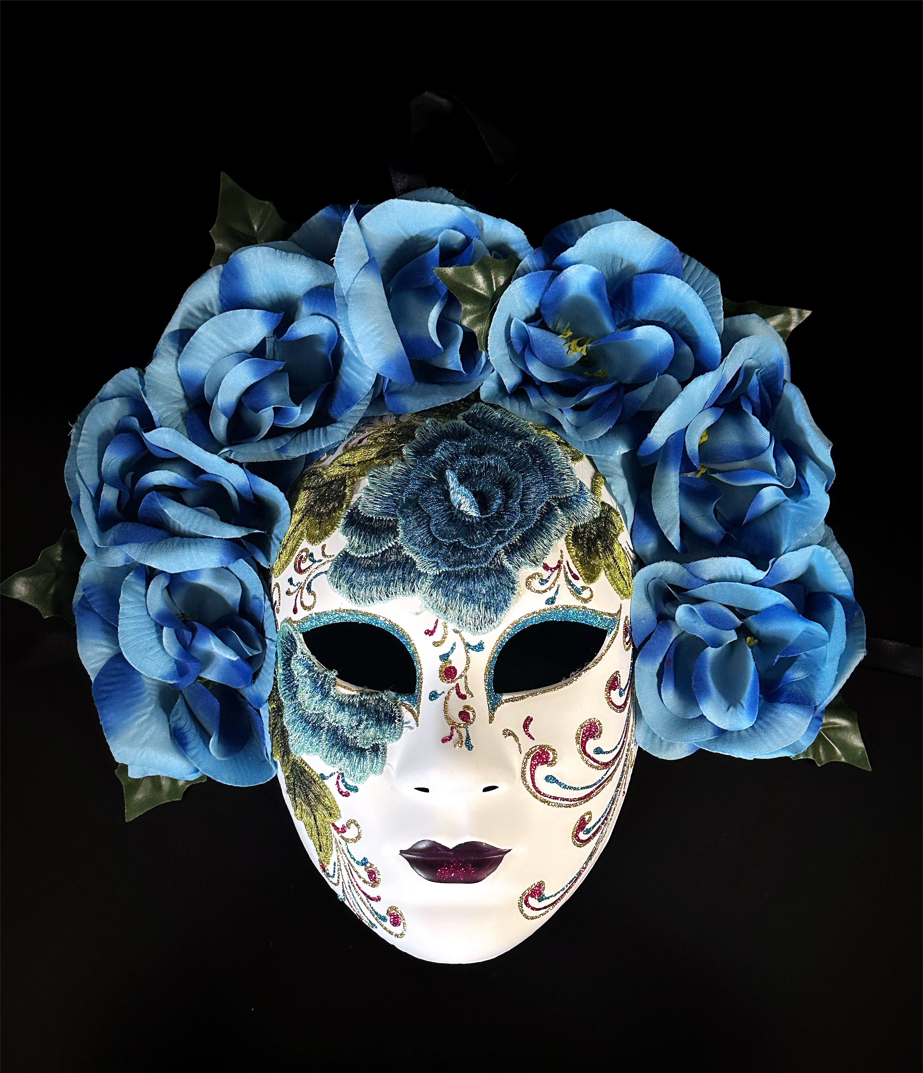 Blue floral mask with embroidered detailing, featuring blue roses and intricate designs, inspired by Venetian craftsmanship