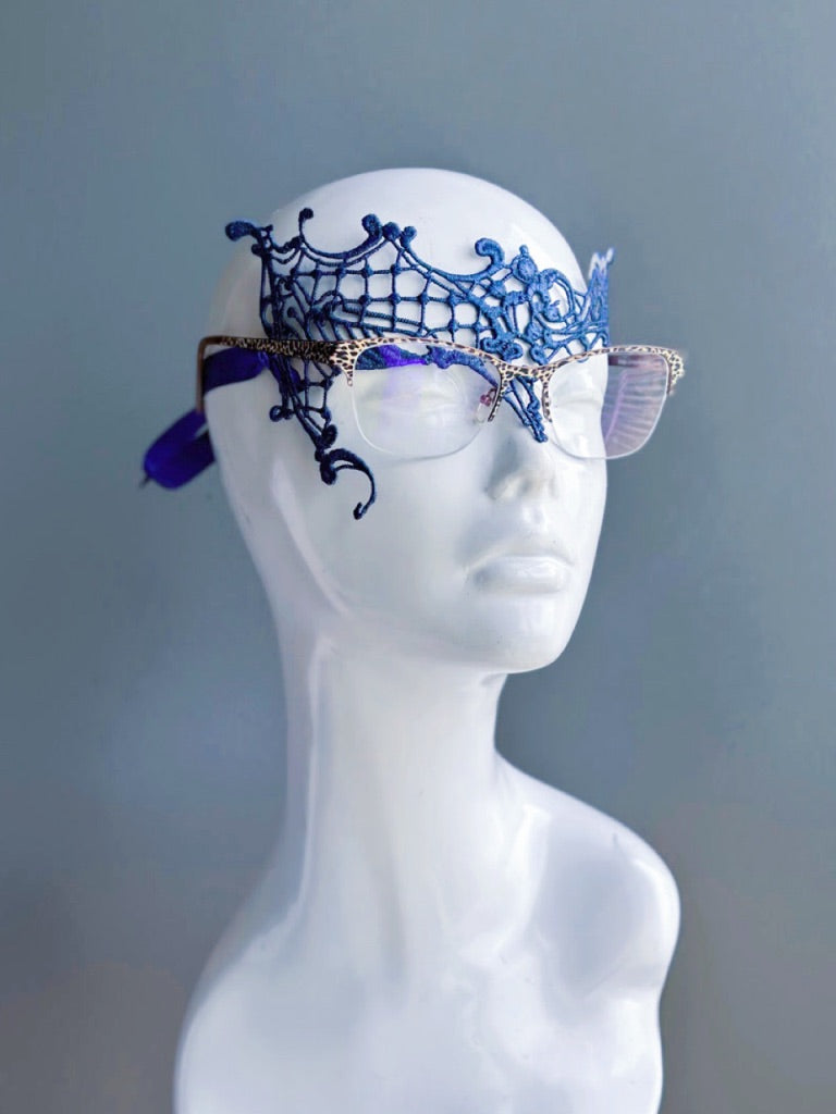 Blue lace mask designed for eyeglass wearers on a white mannequin head