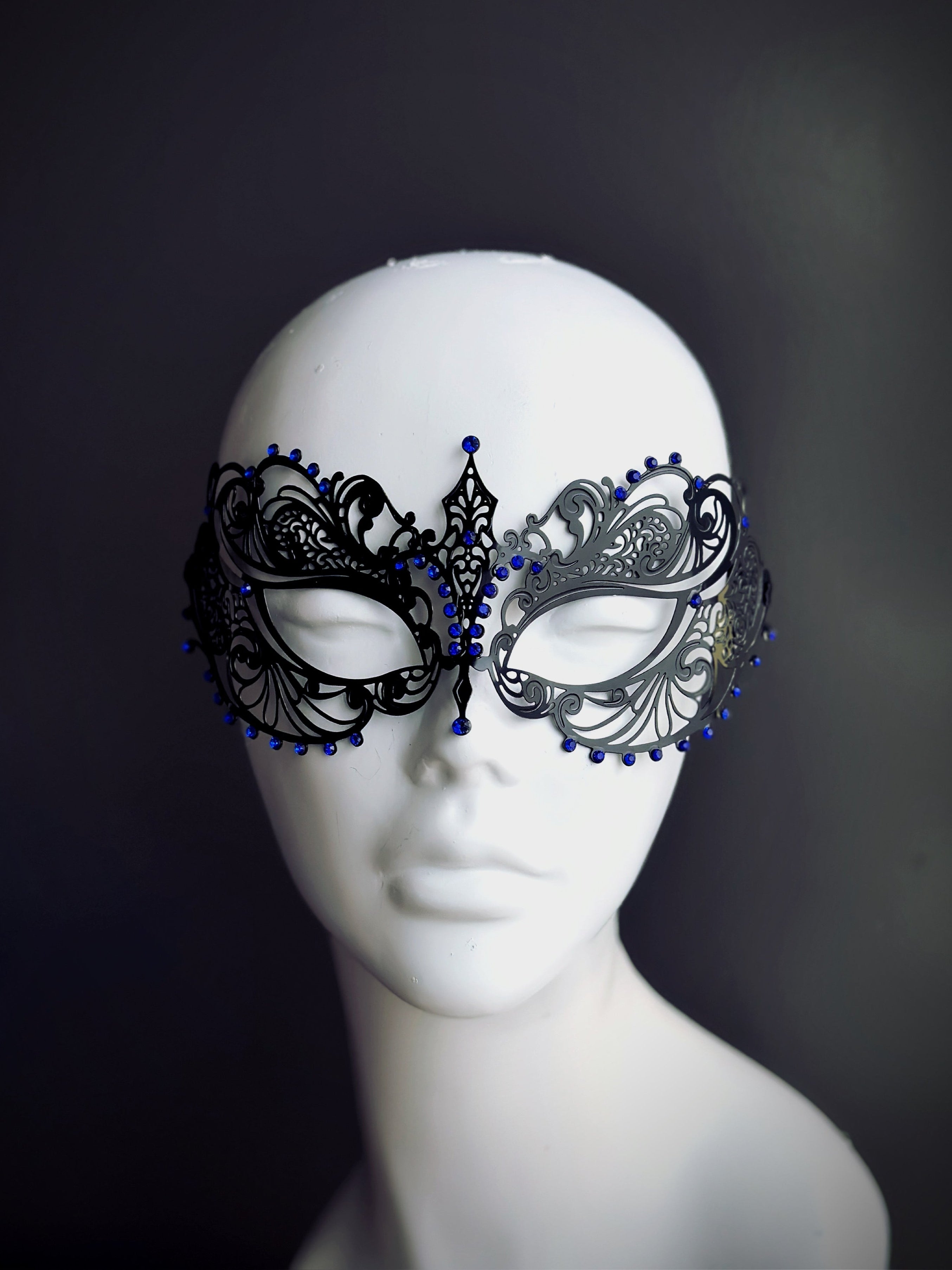 Black filigree metal masquerade mask with blue rhinestones