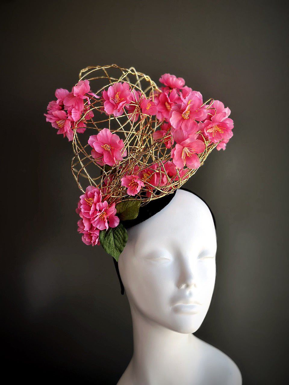 Cherry blossom fascinator hat with pink flowers and gold wire design, ideal for spring parties and race day fashion.