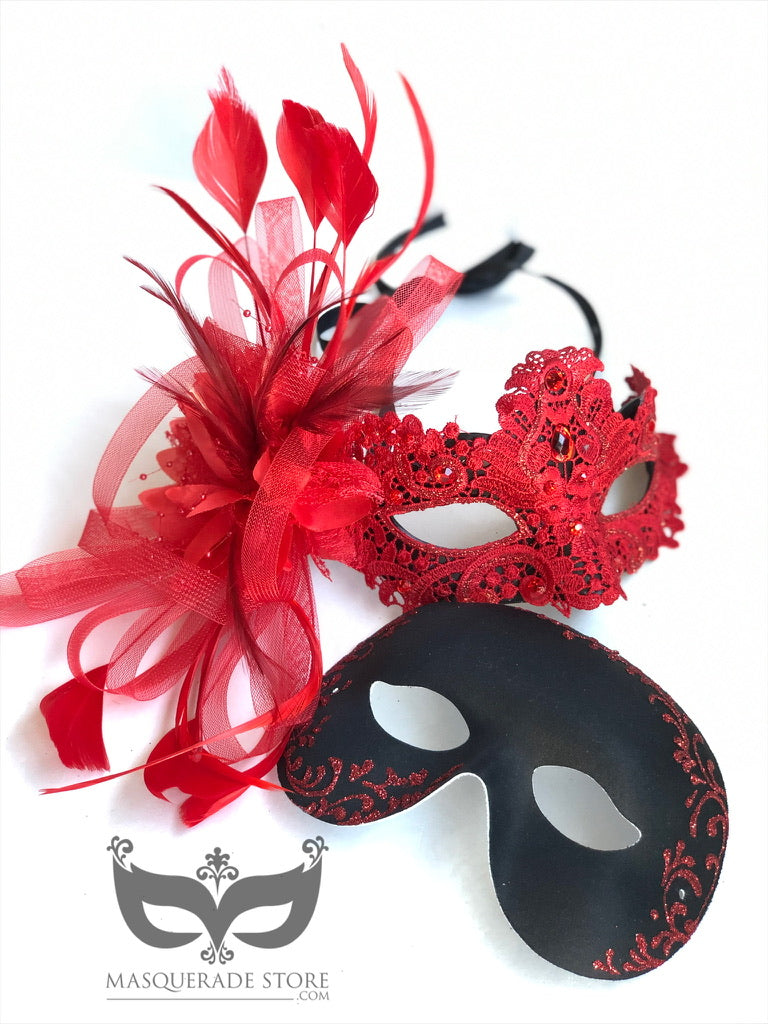 Elegant red and black masquerade mask set with a red lace and feathered rhinestone mask for women and a sleek black filigree mask for men.