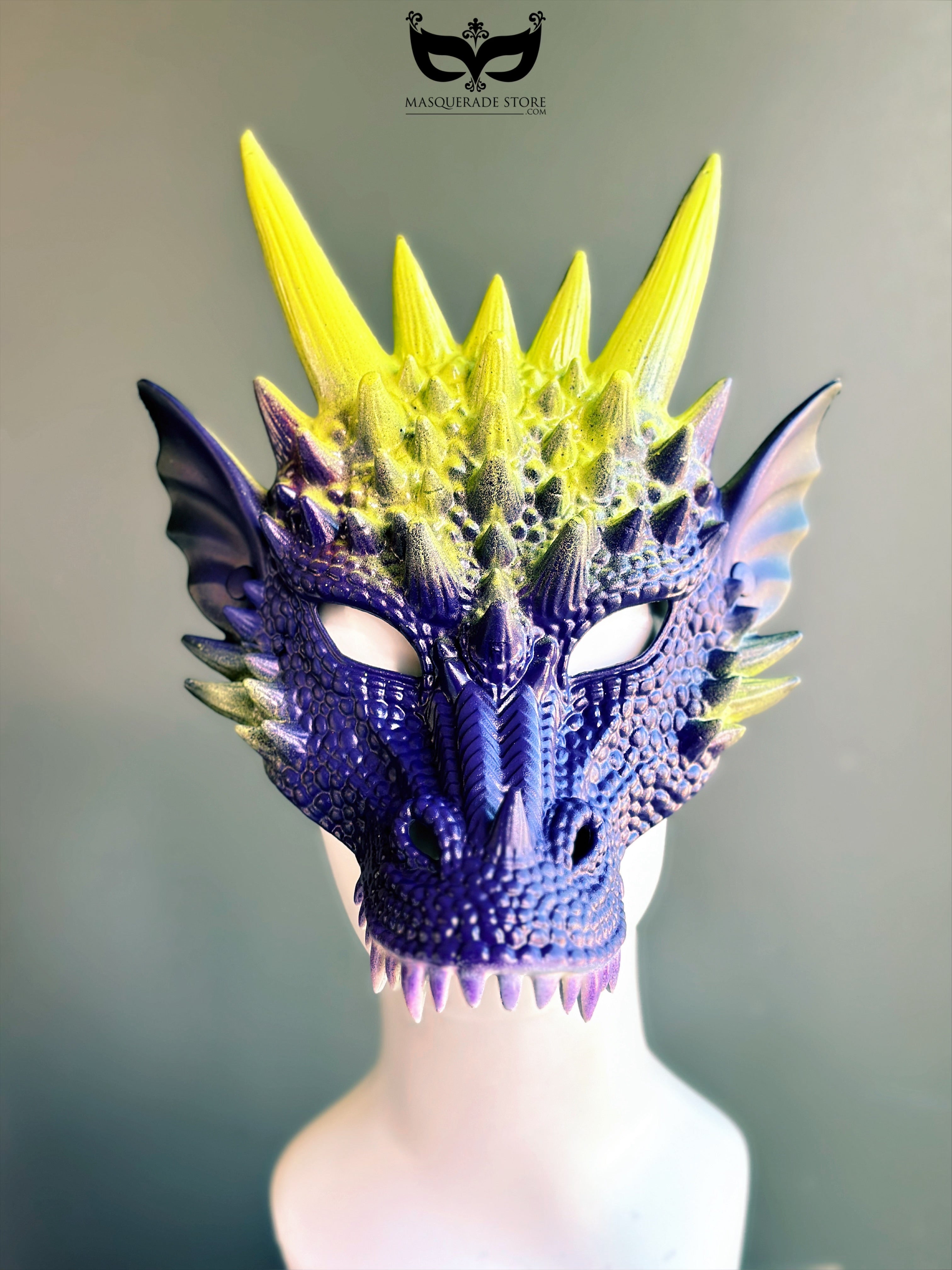 Purple yellow dragon masquerade mask with spiked horns and scales.