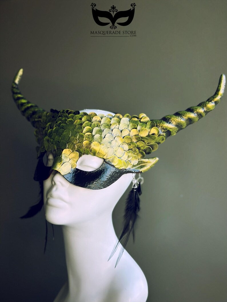 Green dragon horn masquerade mask with emerald scales, long horns, and feather accents, designed as a fantasy headdress.