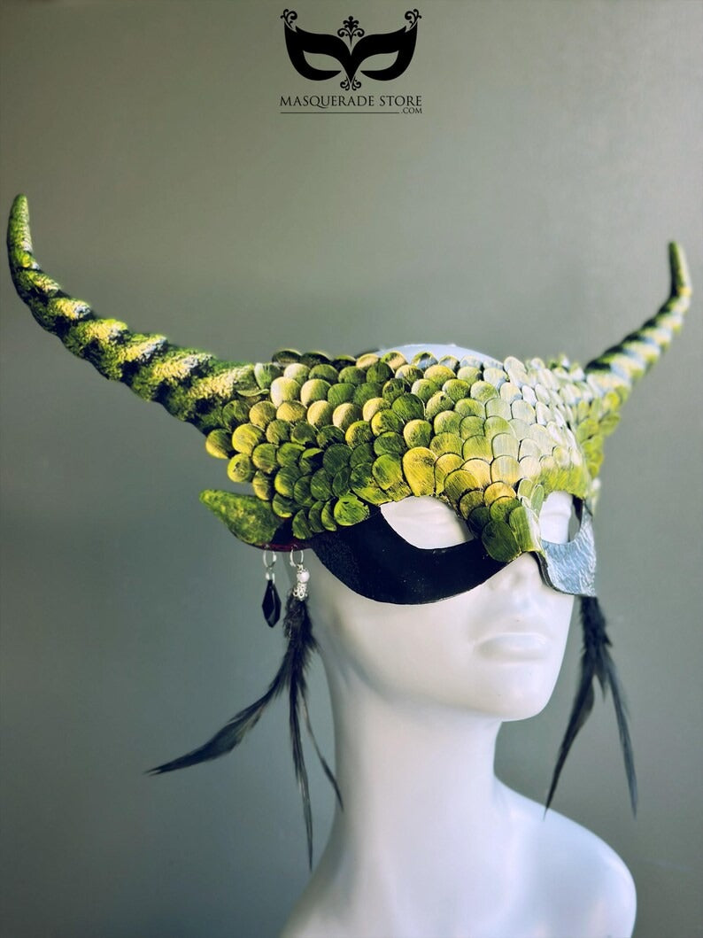 Green dragon horn masquerade mask with emerald scales, long horns, and feather accents, designed as a fantasy headdress.