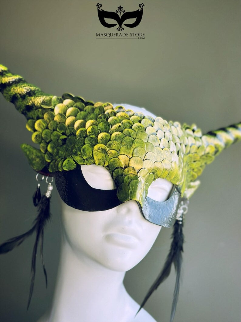 Green dragon horn masquerade mask with emerald scales, long horns, and feather accents, designed as a fantasy headdress.